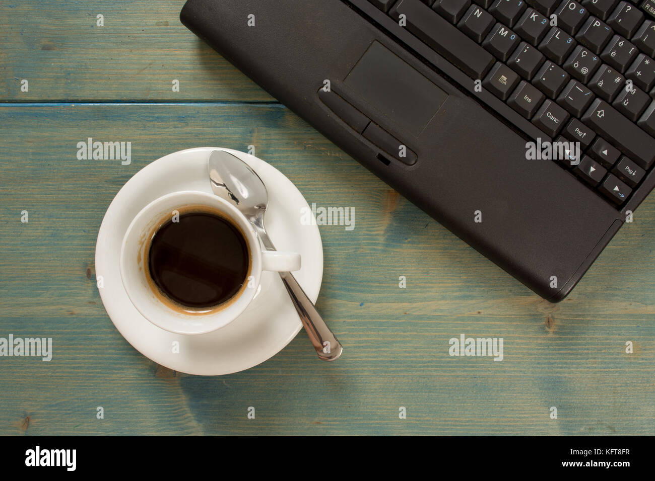 Old wood office table with laptop, cup of coffee vintage style. Top
