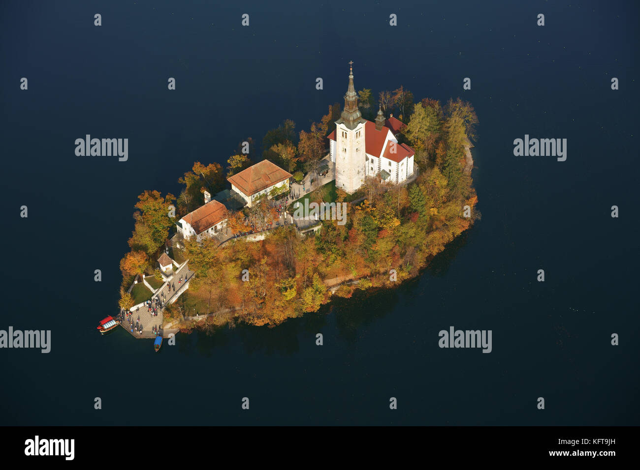 AERIAL VIEW. Bled Island with striking autumnal colors. Lake Bled, Upper Carniola, Slovenia. Stock Photo