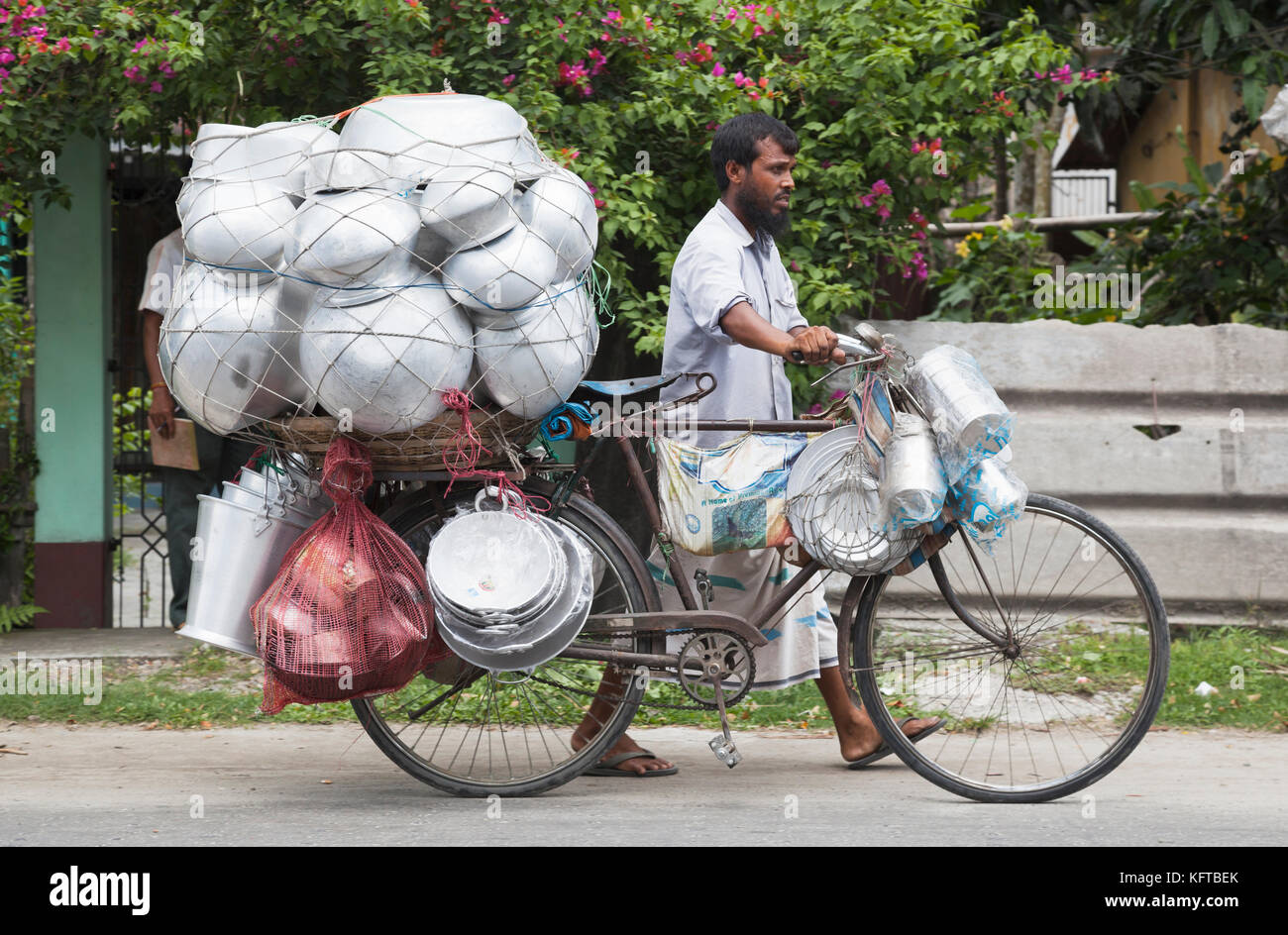 Pot and pan vendor selling his wares from a bicycle in the West Bengal town of Cooch Behar, India Stock Photo