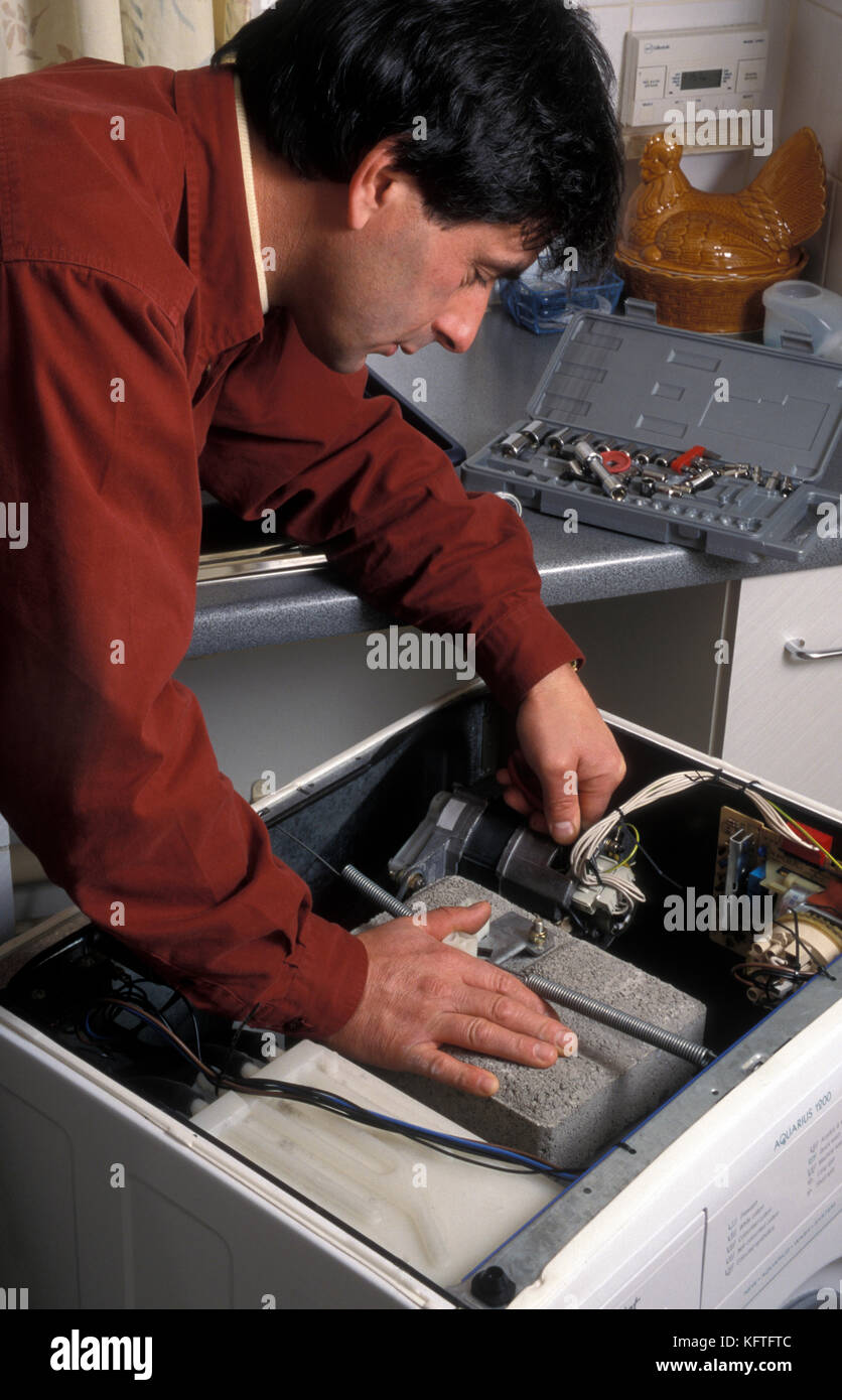 man repairing old washing machine Stock Photo