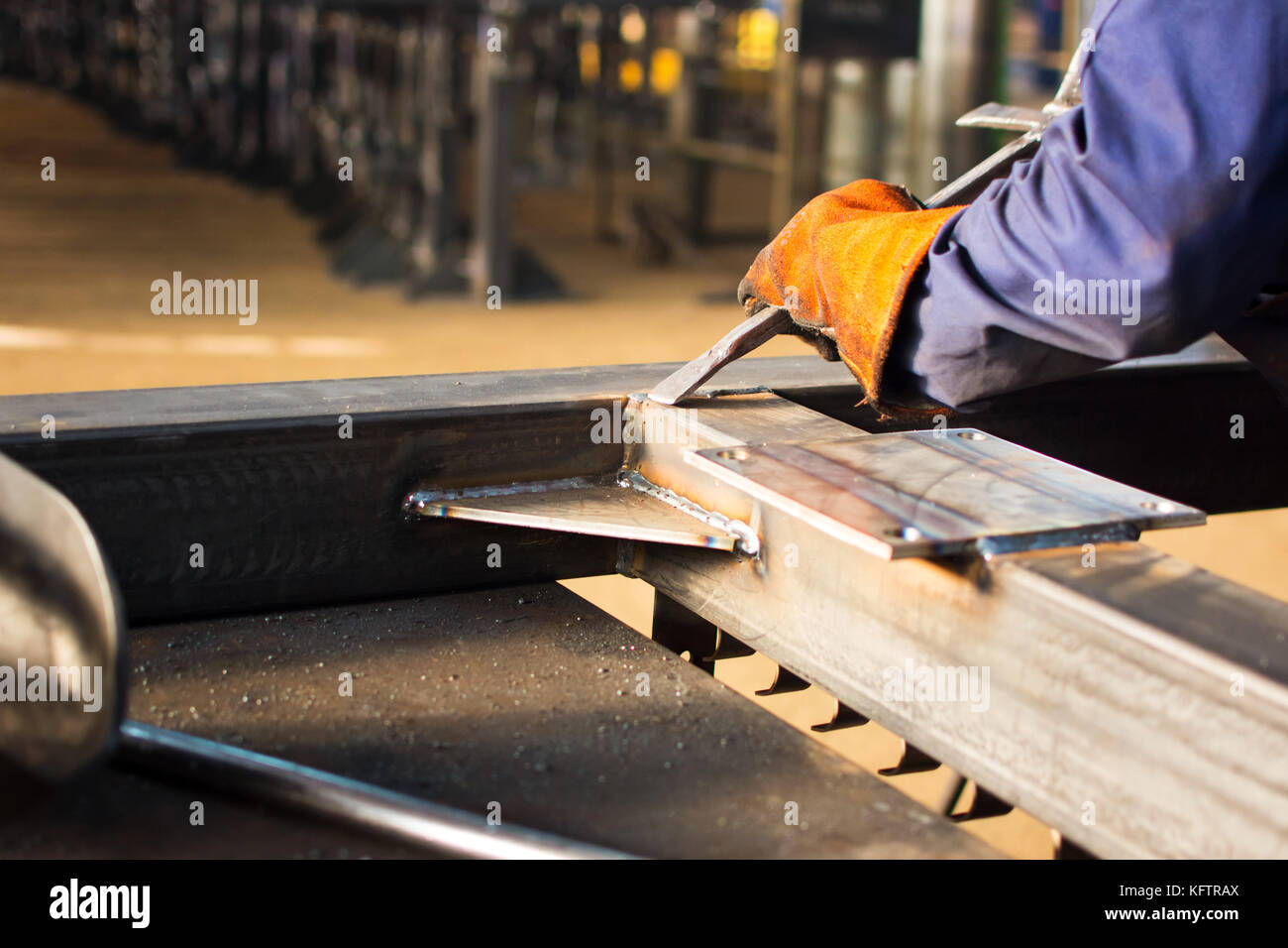 Worker cleaning fresh welded stainless steel bar Stock Photo Alamy