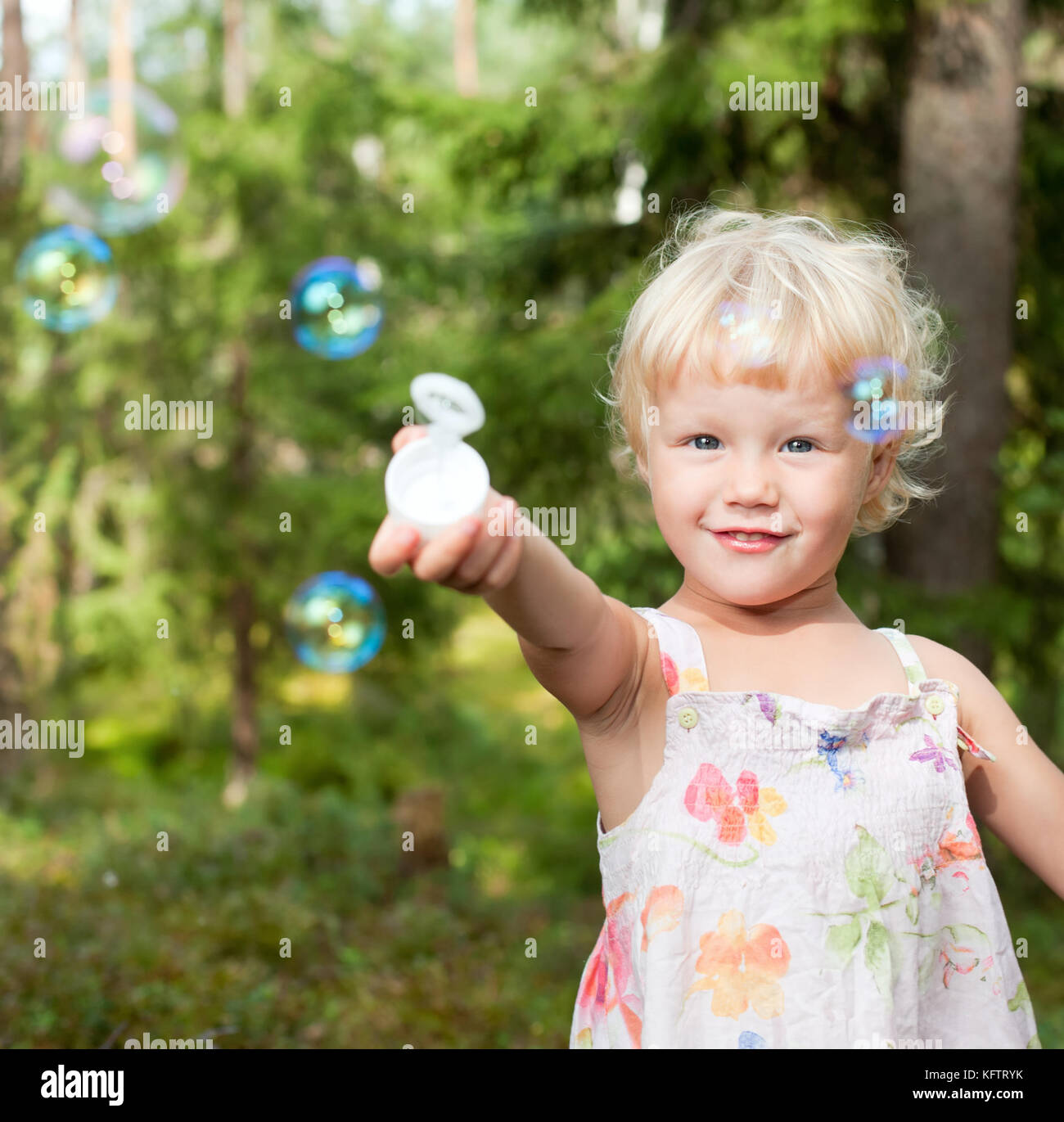Cute little girl playing with soap bubbles outdoors Stock Photo - Alamy