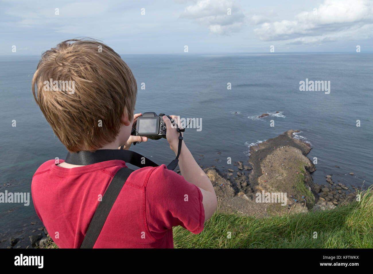 boy taking photos, Giants Causeway, Bushmills, Co. Antrim, Northern Ireland Stock Photo