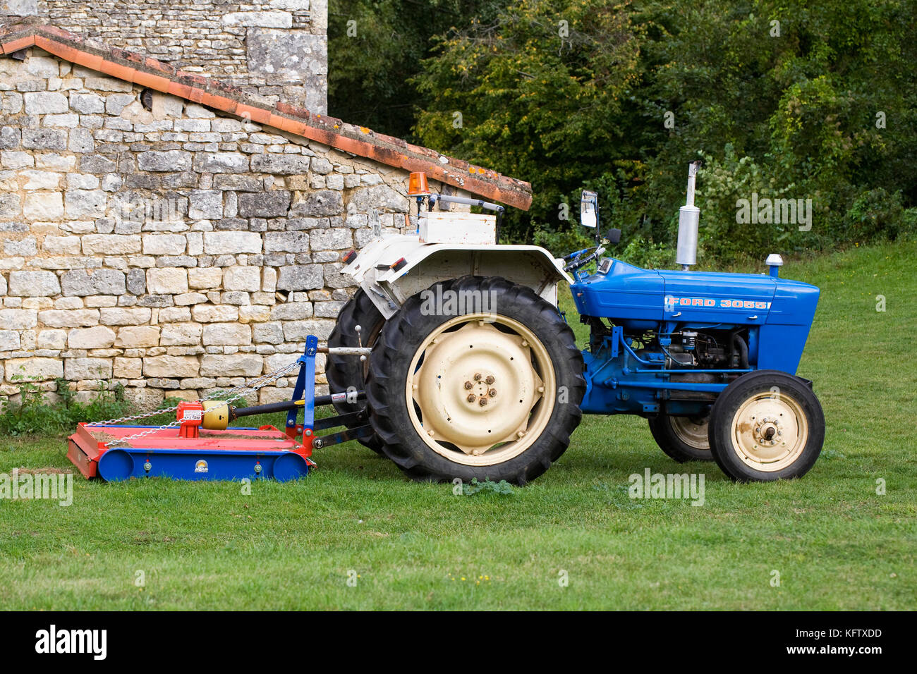 Rotary Lawn Mower attached to a small tractor. Stock Photo