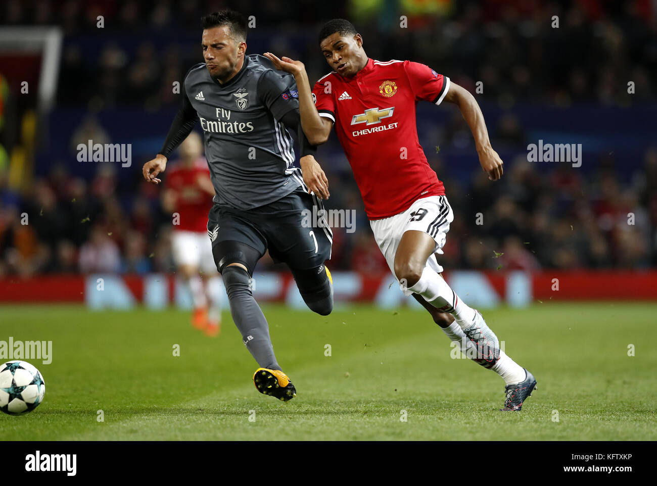 Benfica's Andreas Samaris (left) and Manchester United's Marcus Rashford (right) battle for the ball during the UEFA Champions League, Group A match at Old Trafford, Manchester. Stock Photo