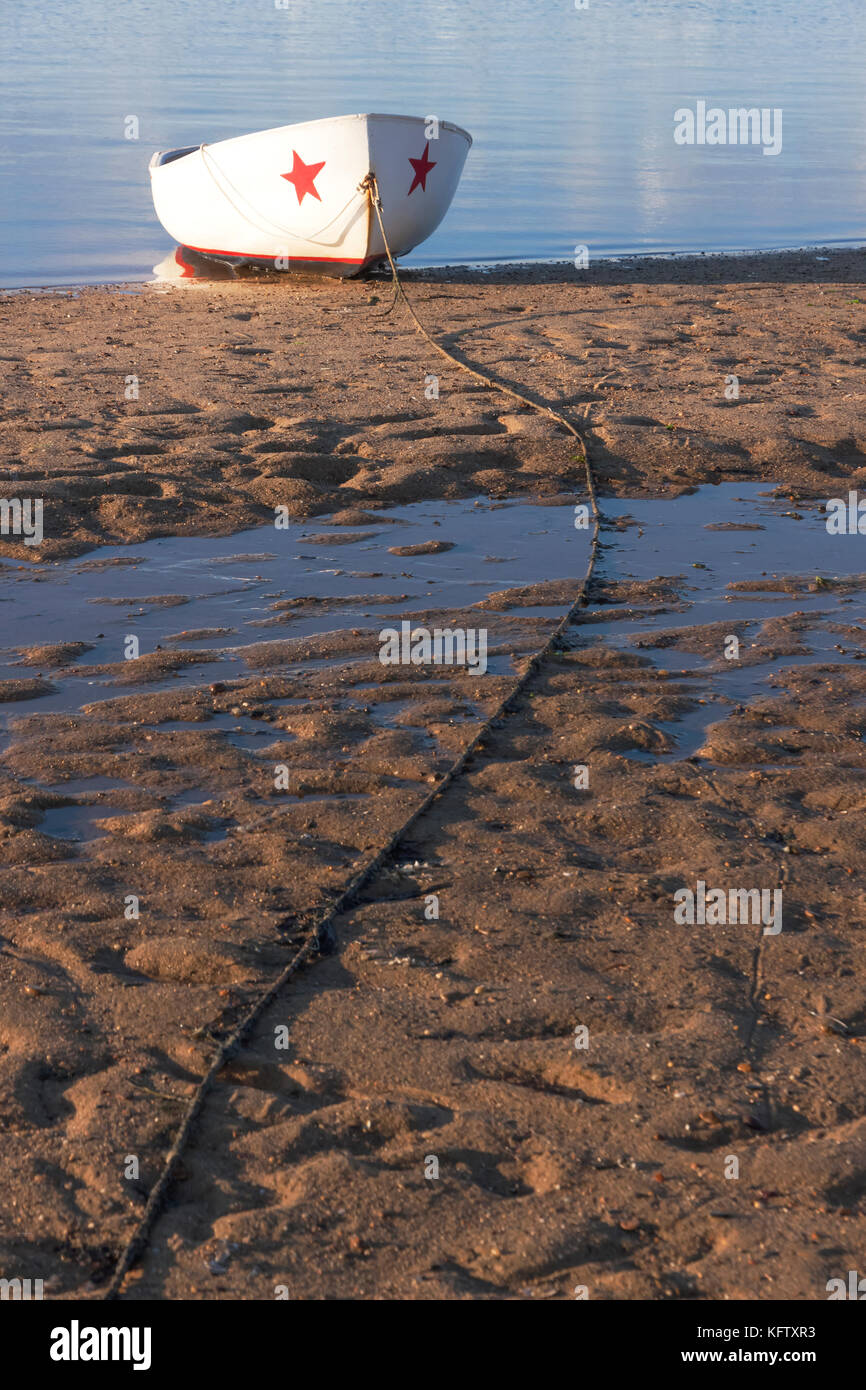 Moored wooden boat in sand at low tide. Stock Photo