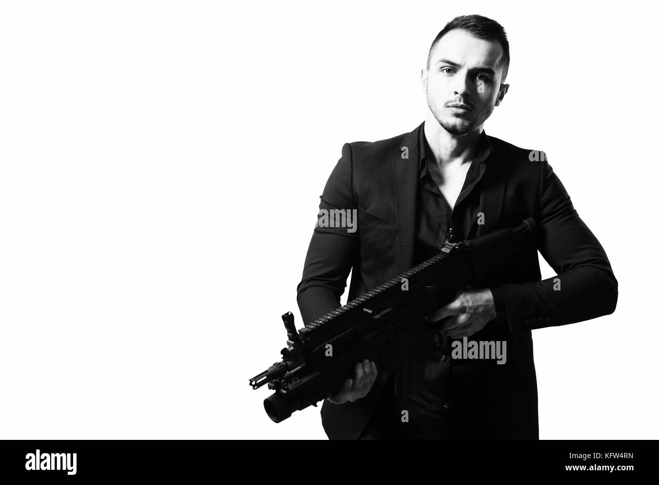 Man Isolated on a White Background With a Handgun as He Turns and Aims Off Camera Stock Photo