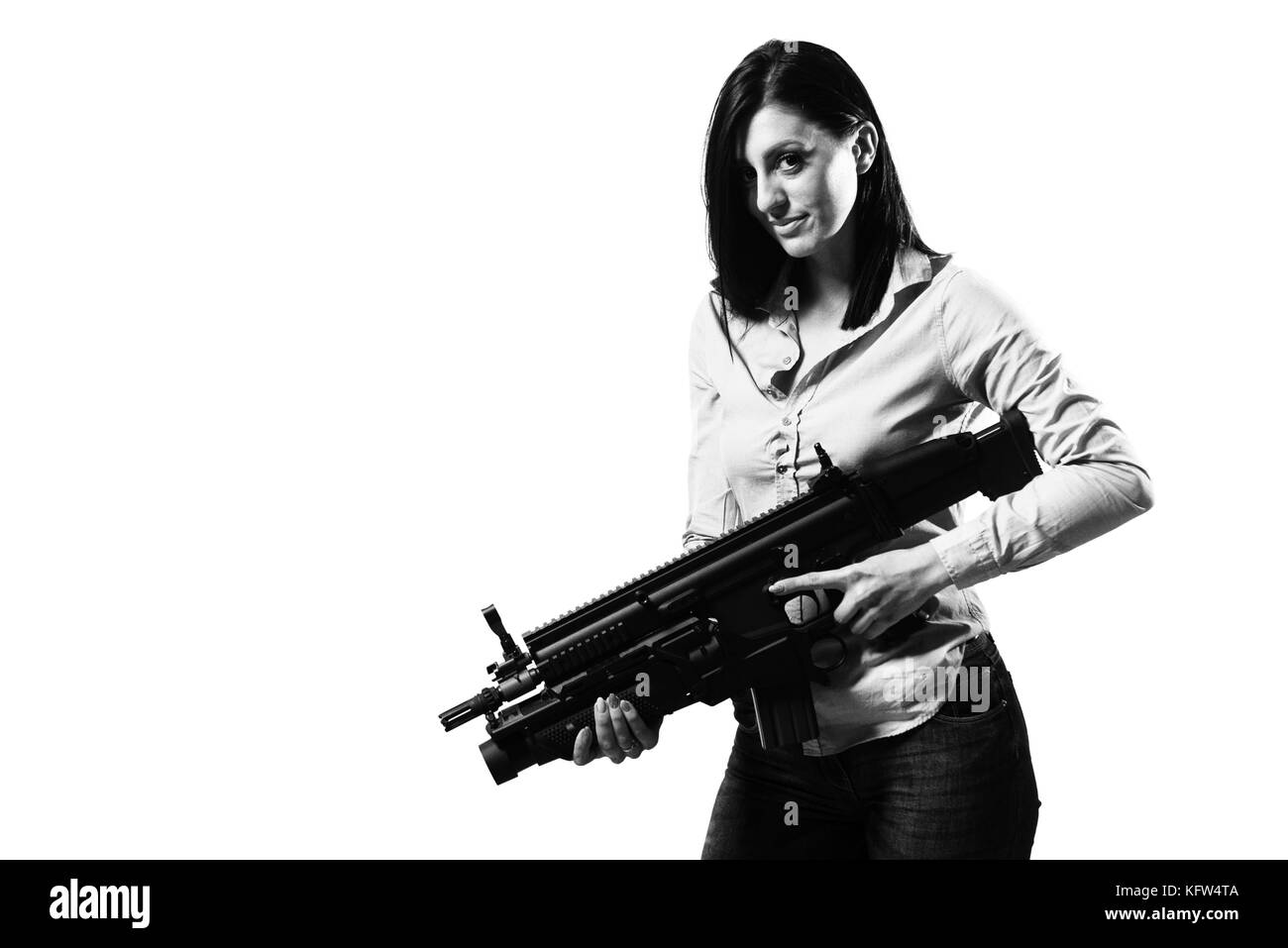 Woman Isolated on a White Background With a Handgun as She Turns and Aims Off Camera Stock Photo