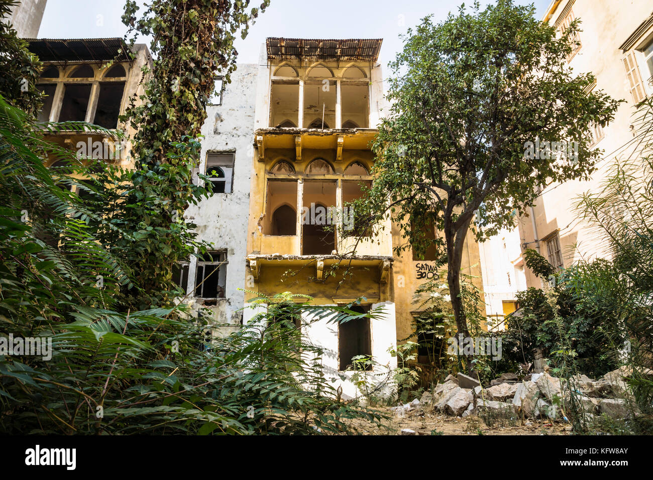 Ruins of a traditional lebanese house surrounded by trees and bushes in