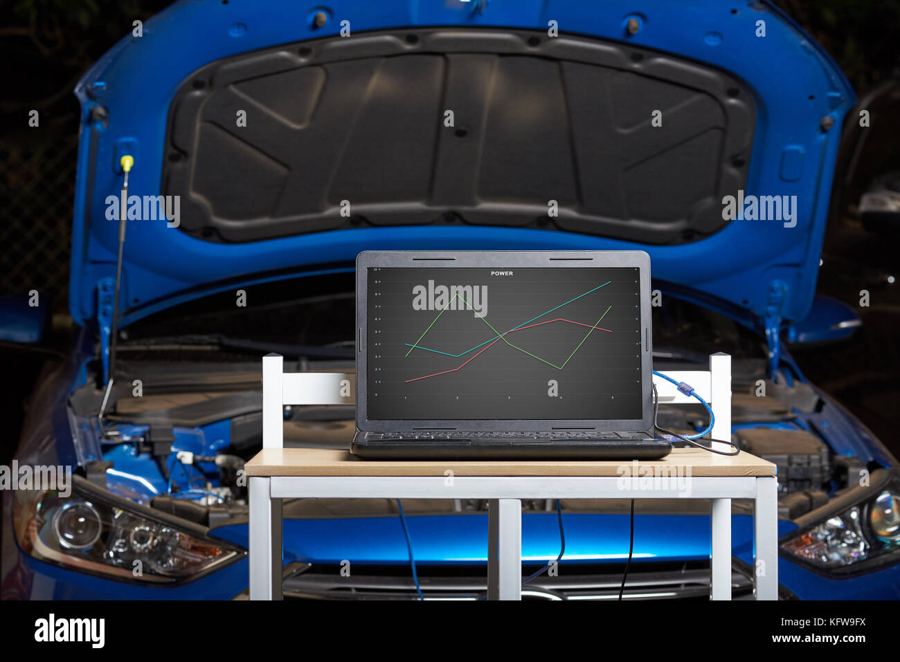 Car computer diagnostic concept. Table with laptop show car perfomance Stock Photo