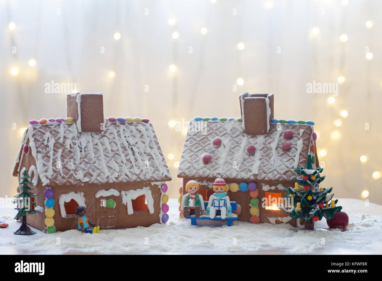Two gingerbread houses, tree and people sitting on a bench, winter ...