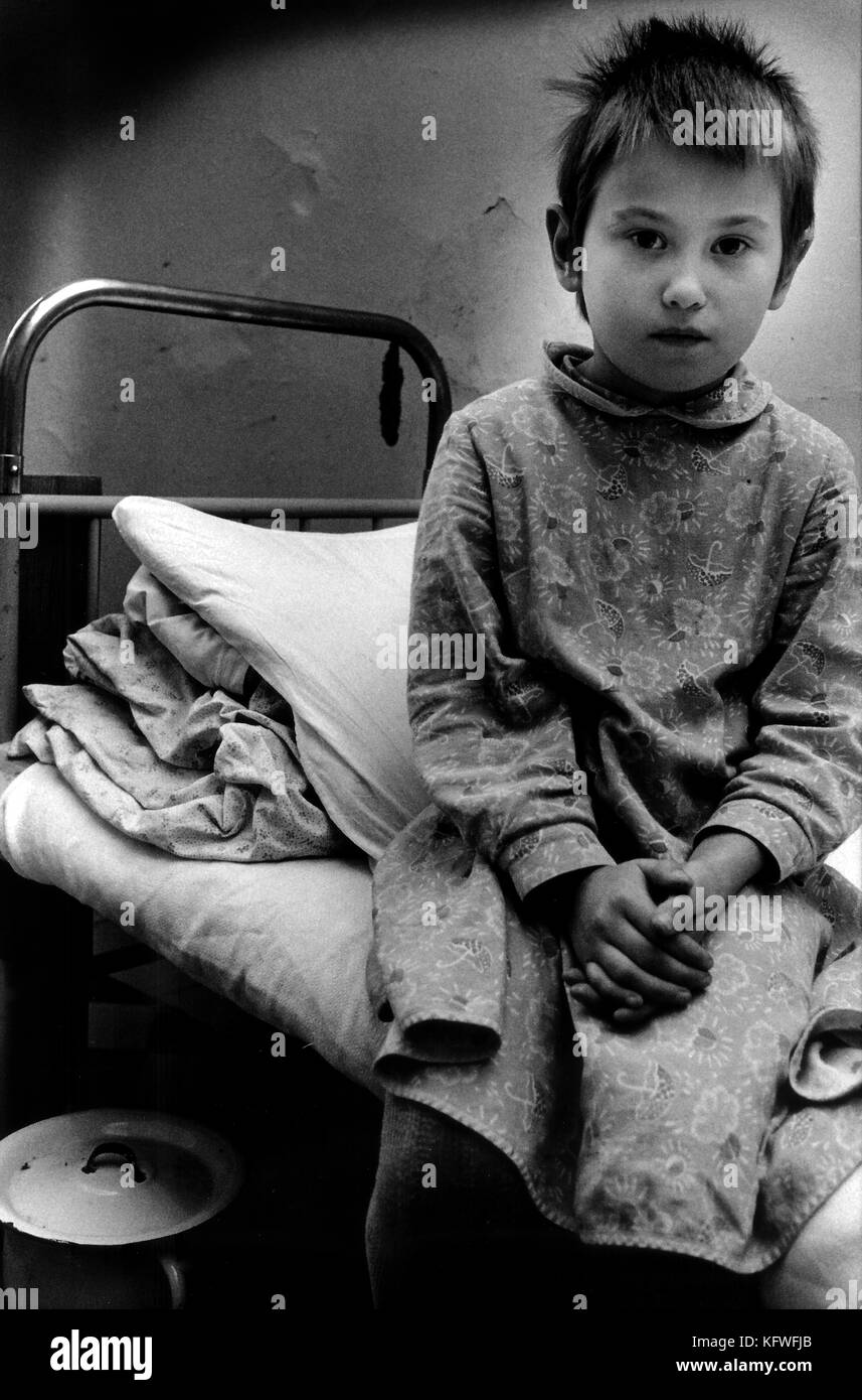 Young girl sitting alone on bed. TSIMBALINA HOSPITAL for abandoned children in NEVSKII RAYON area St Petersburg Russia. Children 2- 10 yrs spend 24 hours in quarantine to check for disease. They can stay for up to 6 months then go into children's home. Stock Photo