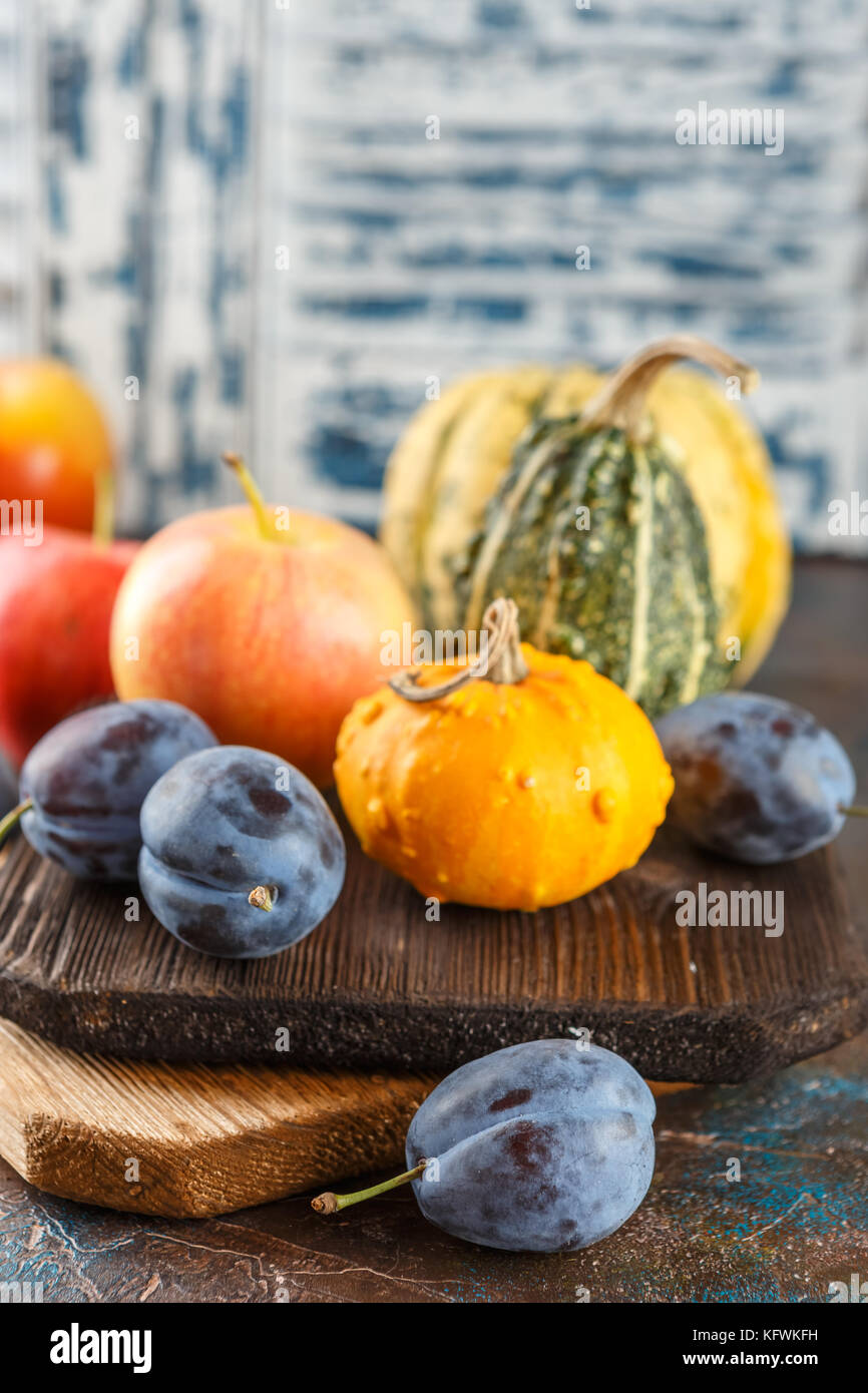 Autumn still life with vegetables and fruits - pumpkins, apples, plums ...