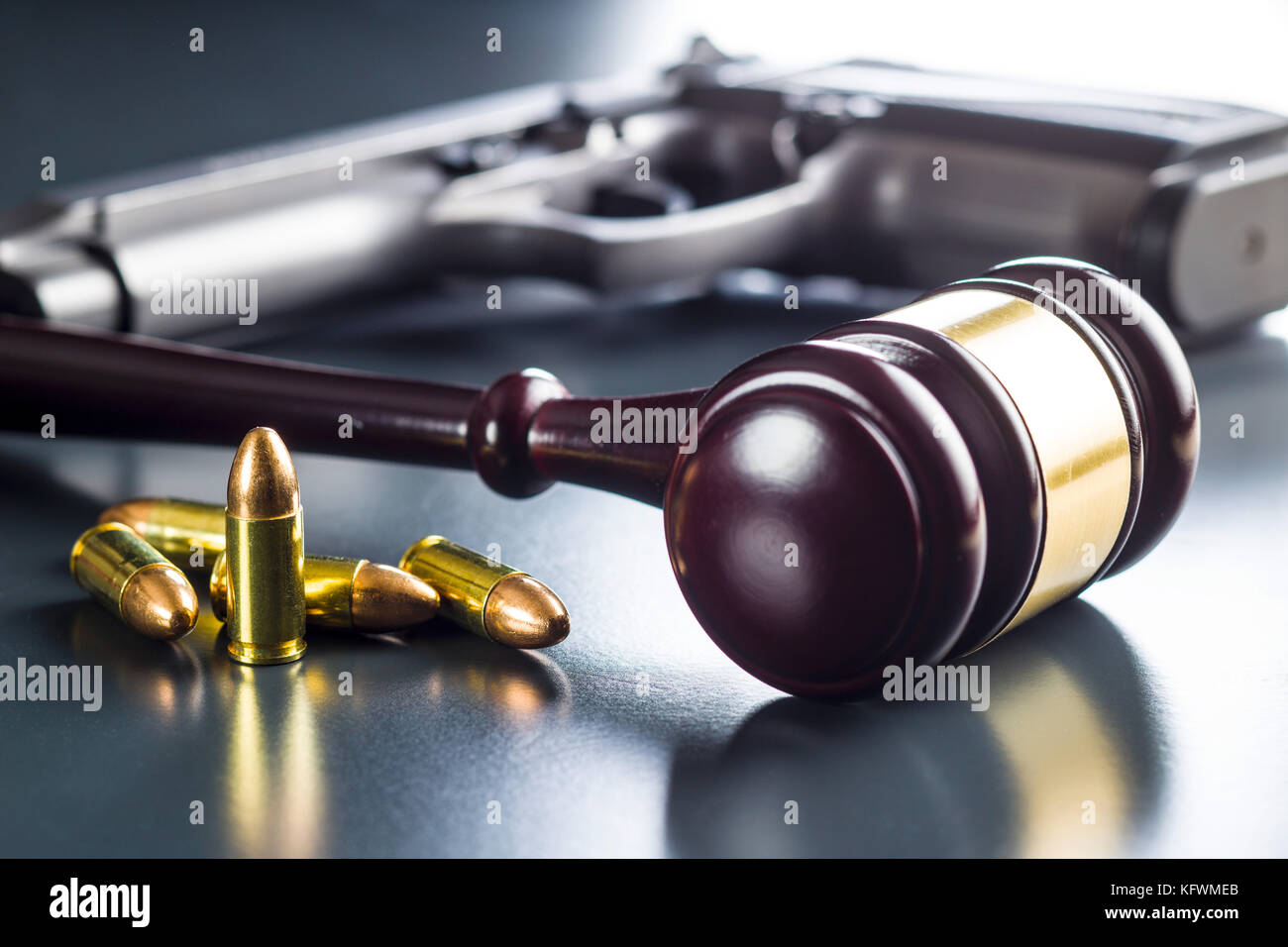 Judge gavel and gun bullets on black table. Stock Photo
