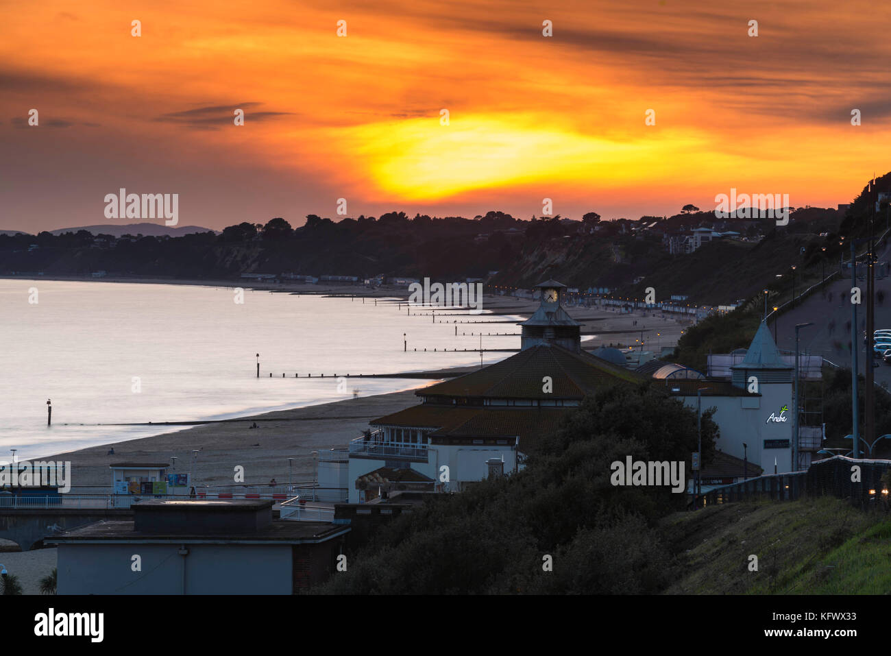 Bournemouth, Dorset, UK. 1st November 2017.  UK Weather.   The sun sets behind a bank of high cloud seen from Bournemouth seafront looking West along the beach.  Photo Credit: Graham Hunt/Alamy Live News Stock Photo