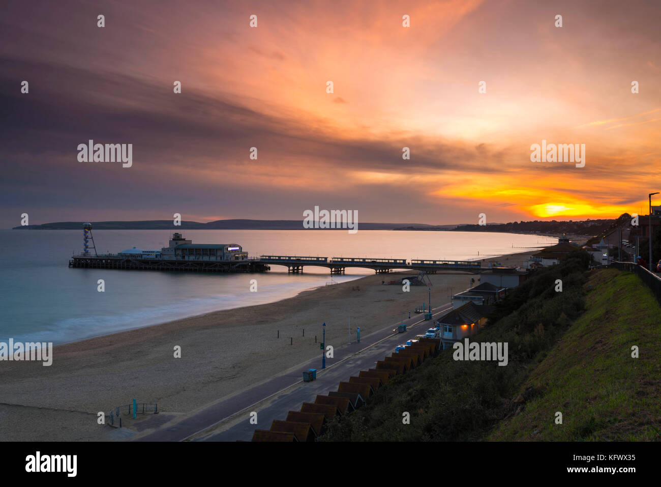 Bournemouth, Dorset, UK. 1st November 2017.  UK Weather.   The sun sets behind a bank of high cloud seen from Bournemouth seafront looking West across the pier towards Poole.  Photo Credit: Graham Hunt/Alamy Live News Stock Photo