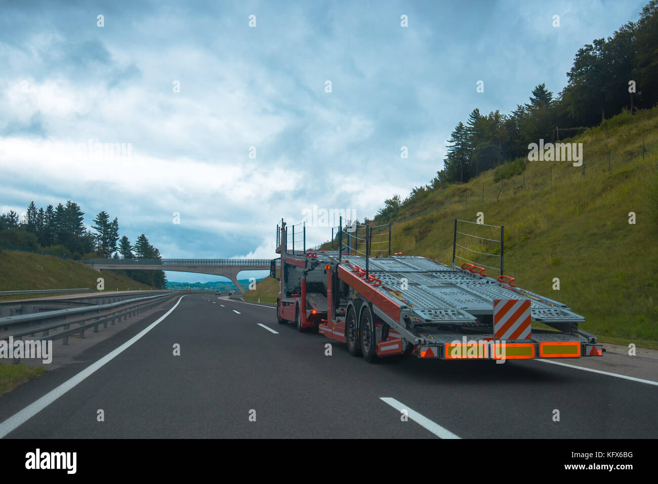 Semi truck with empty car carrier trailer on highway road Stock Photo