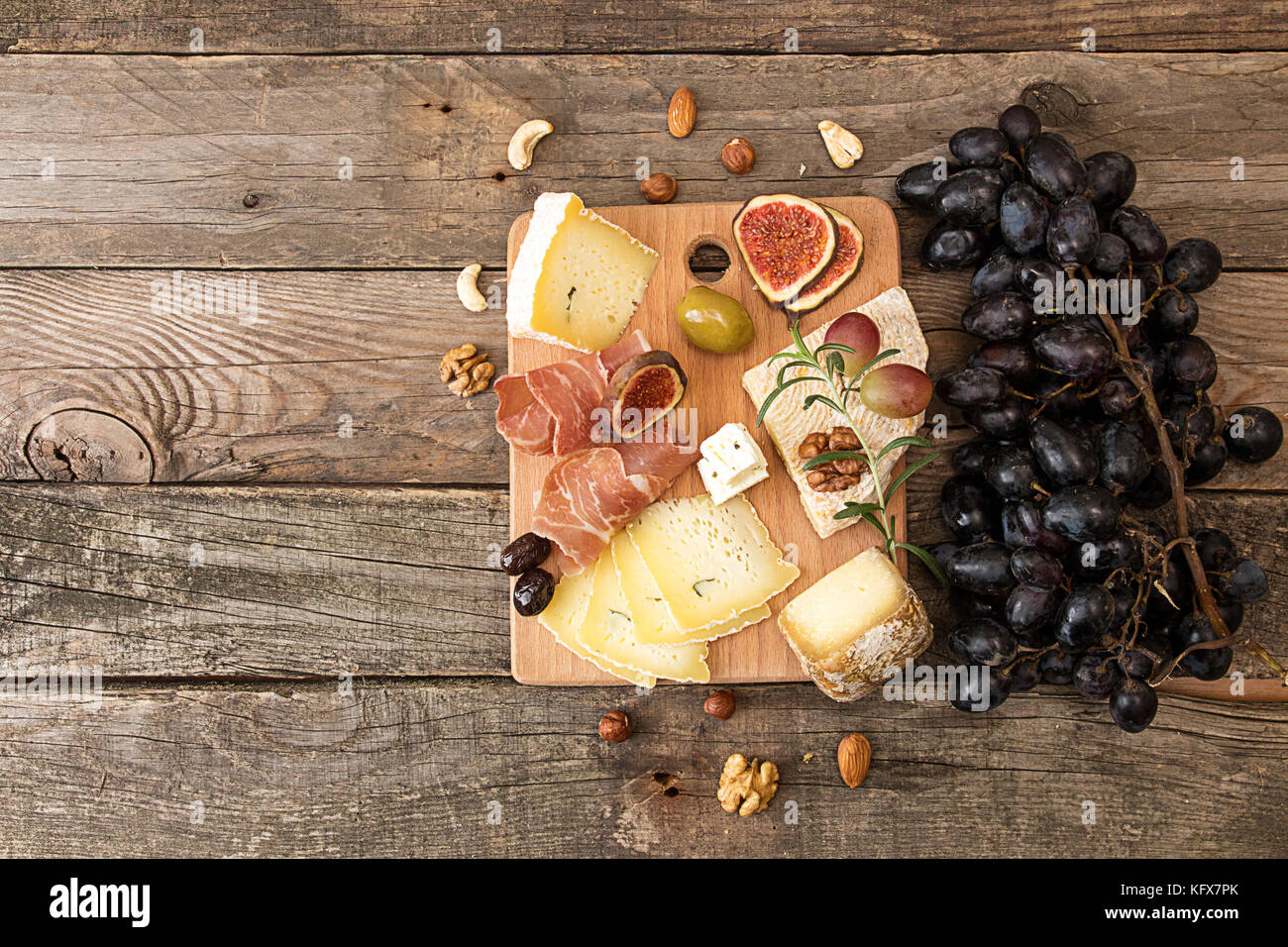 cheese plate with pieces moldy cheese, prosciutto, pickled plums