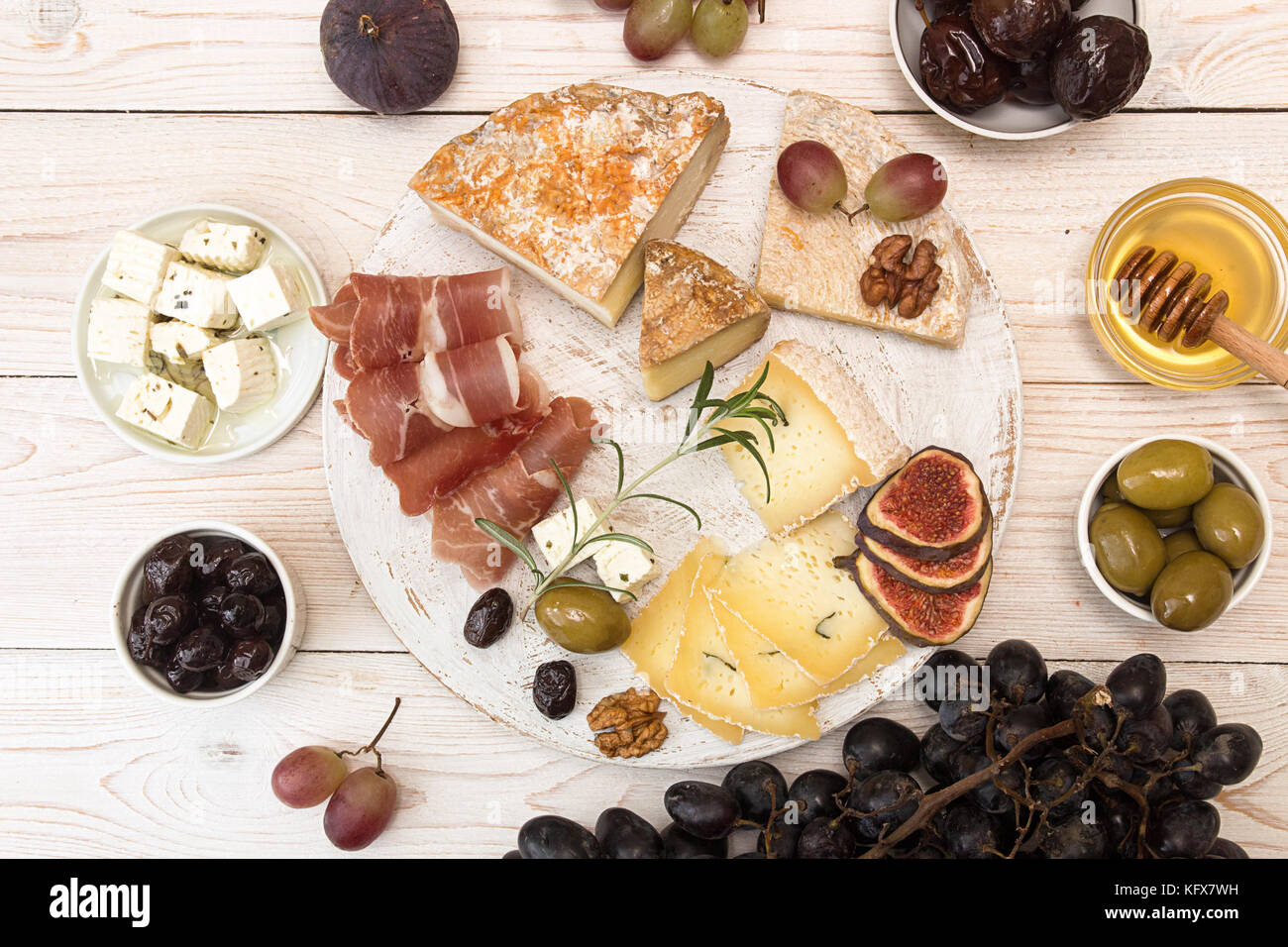 Overhead of cheese plate with pieces moldy cheese, prosciutto, pickled
