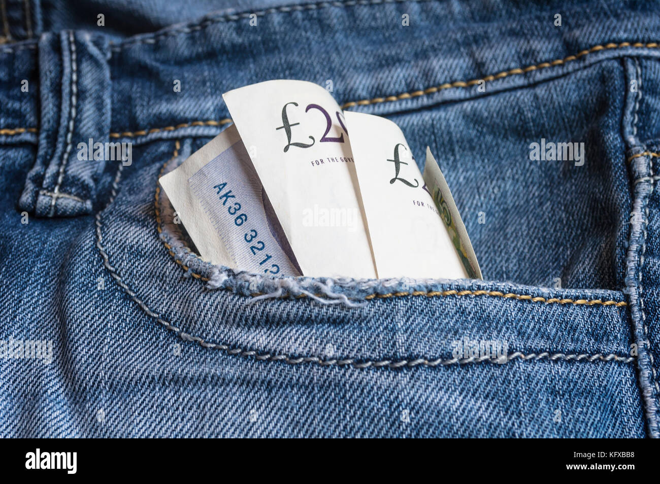 UK Pounds banknotes in blue denim pocket. Concept on earning and saving money. Stock Photo