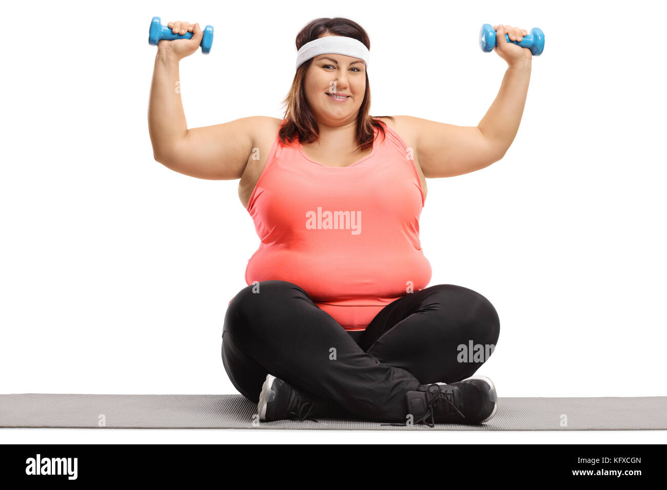 Overweight Woman Exercising With Small Dumbbells On An Exercise