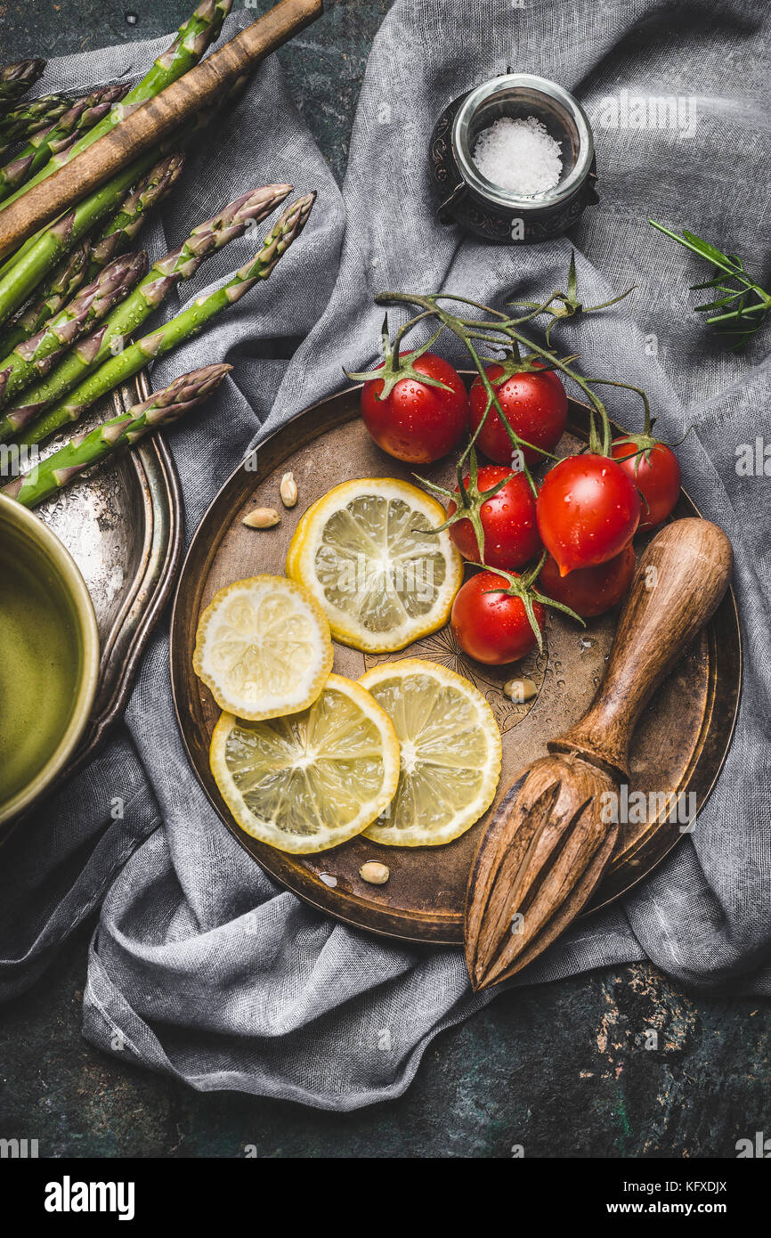 Asparagus cooking ingredients with kitchen tools on rustic napkin background, top view.   Dark style Stock Photo
