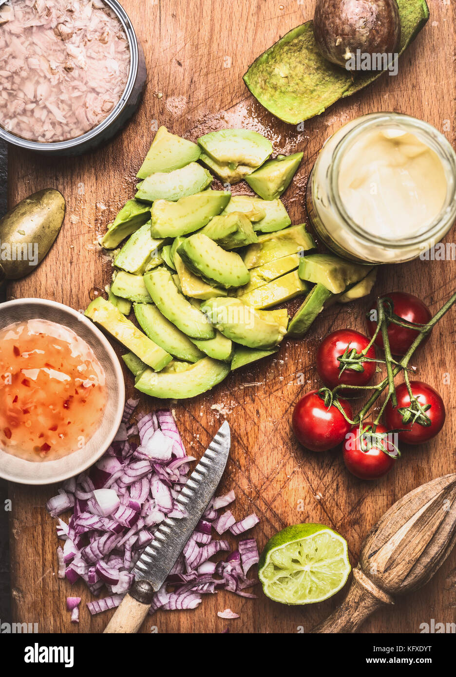Cut avocado with knife and Healthy cooking ingredients for tasty salad or dip , top view Stock Photo