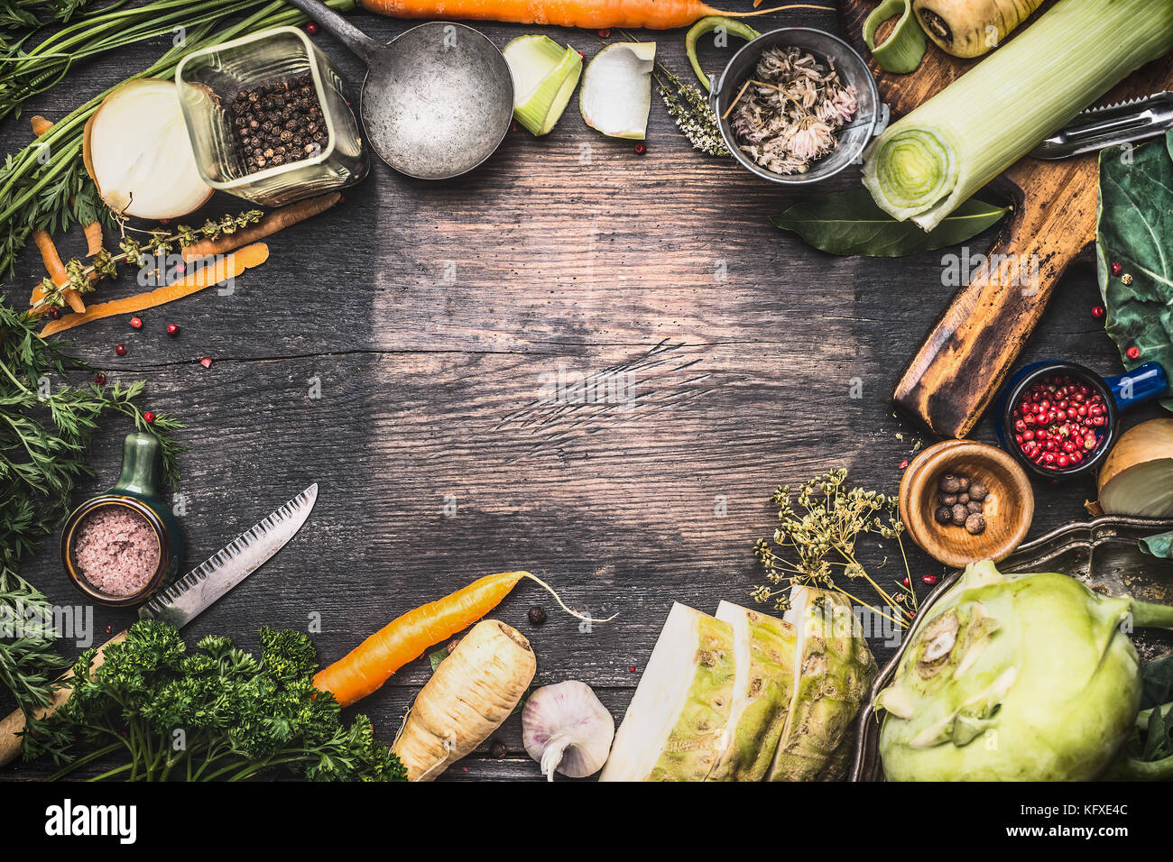Healthy vegetarian cooking ingredients for soup or stew. Raw organic vegetables with kitchen tools on dark rustic wooden background, top view. Country Stock Photo