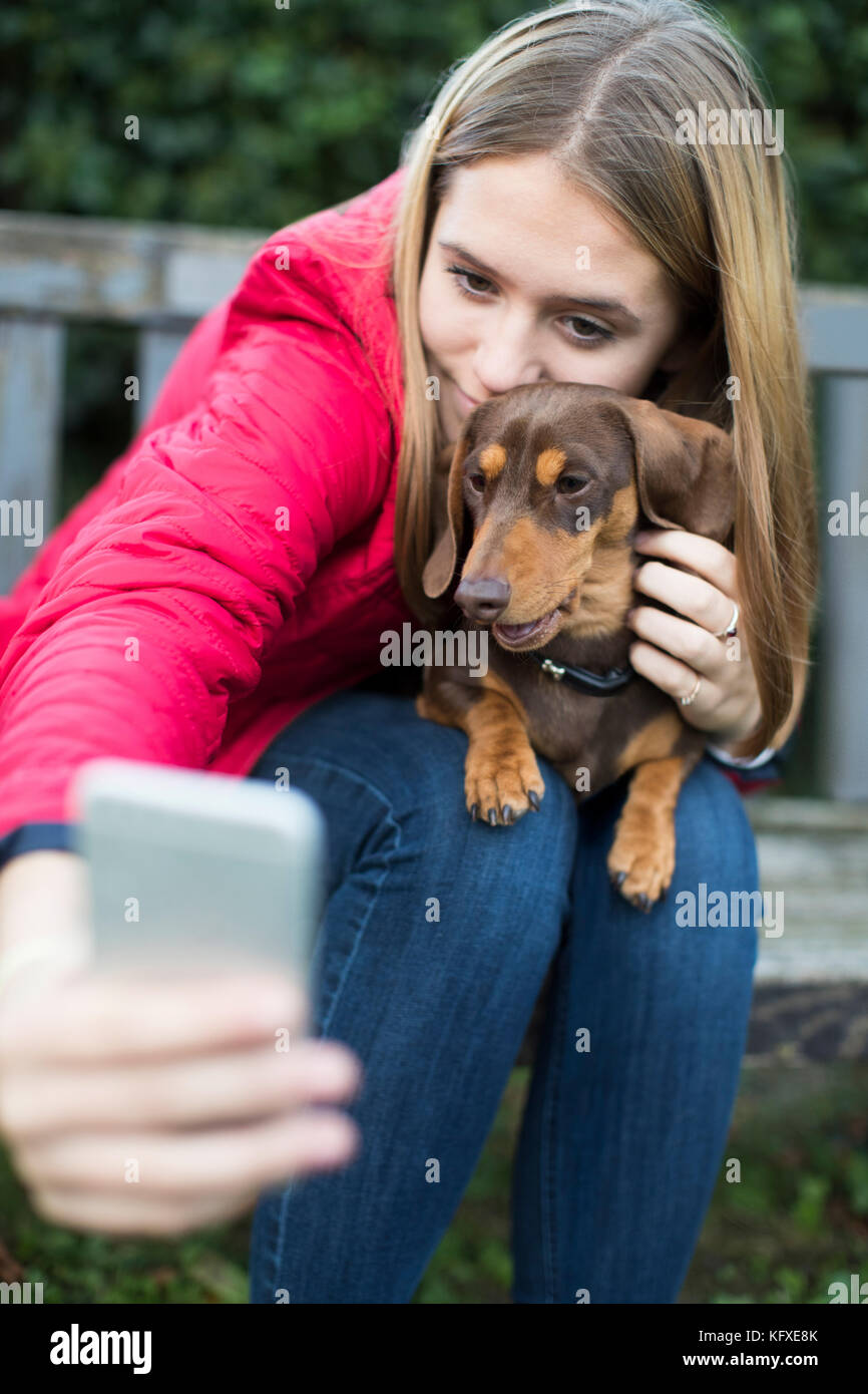 Teenage Girl With Pet Dachshund Posing For Selfie Stock Photo
