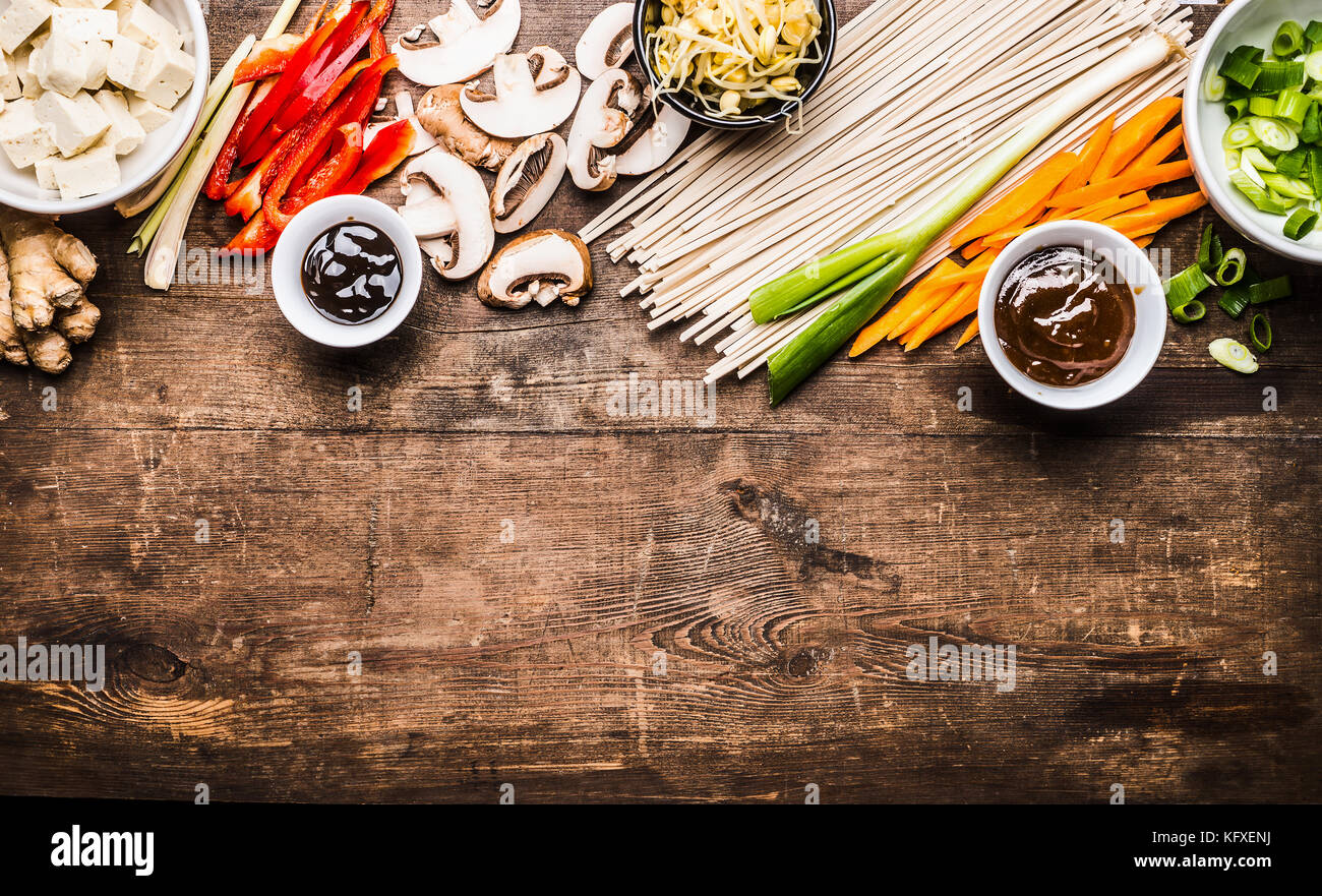 Asian vegetarian cooking ingredients for stir fry with tofu, noodles, ginger, cut vegetables, Sprout,green onion , lemongrass, hoisin and austern sauc Stock Photo