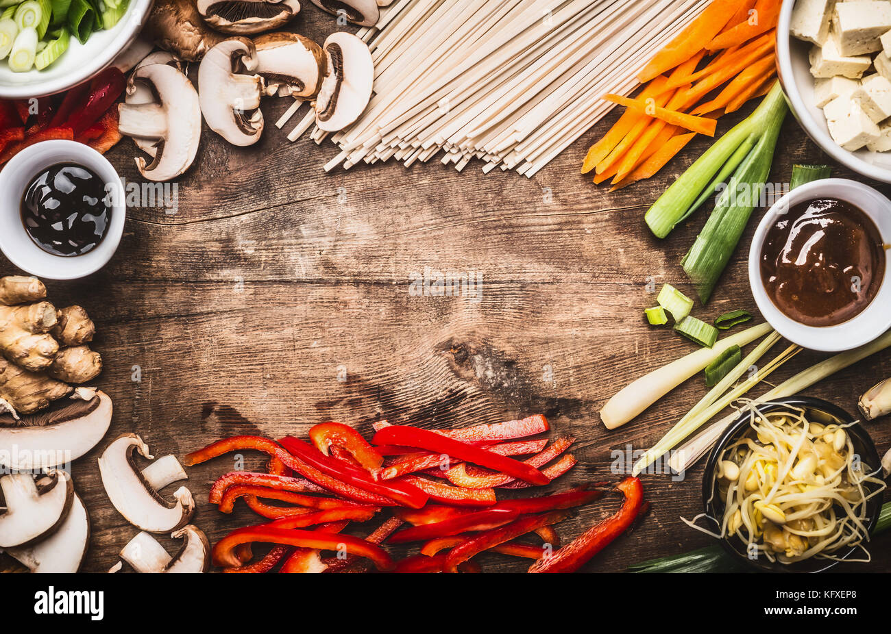 Asian food background with vegetarian cooking ingredients and chopsticks : tofu, noodles, ginger, lemongrass, cut vegetables, Sprout,green onion ,hois Stock Photo