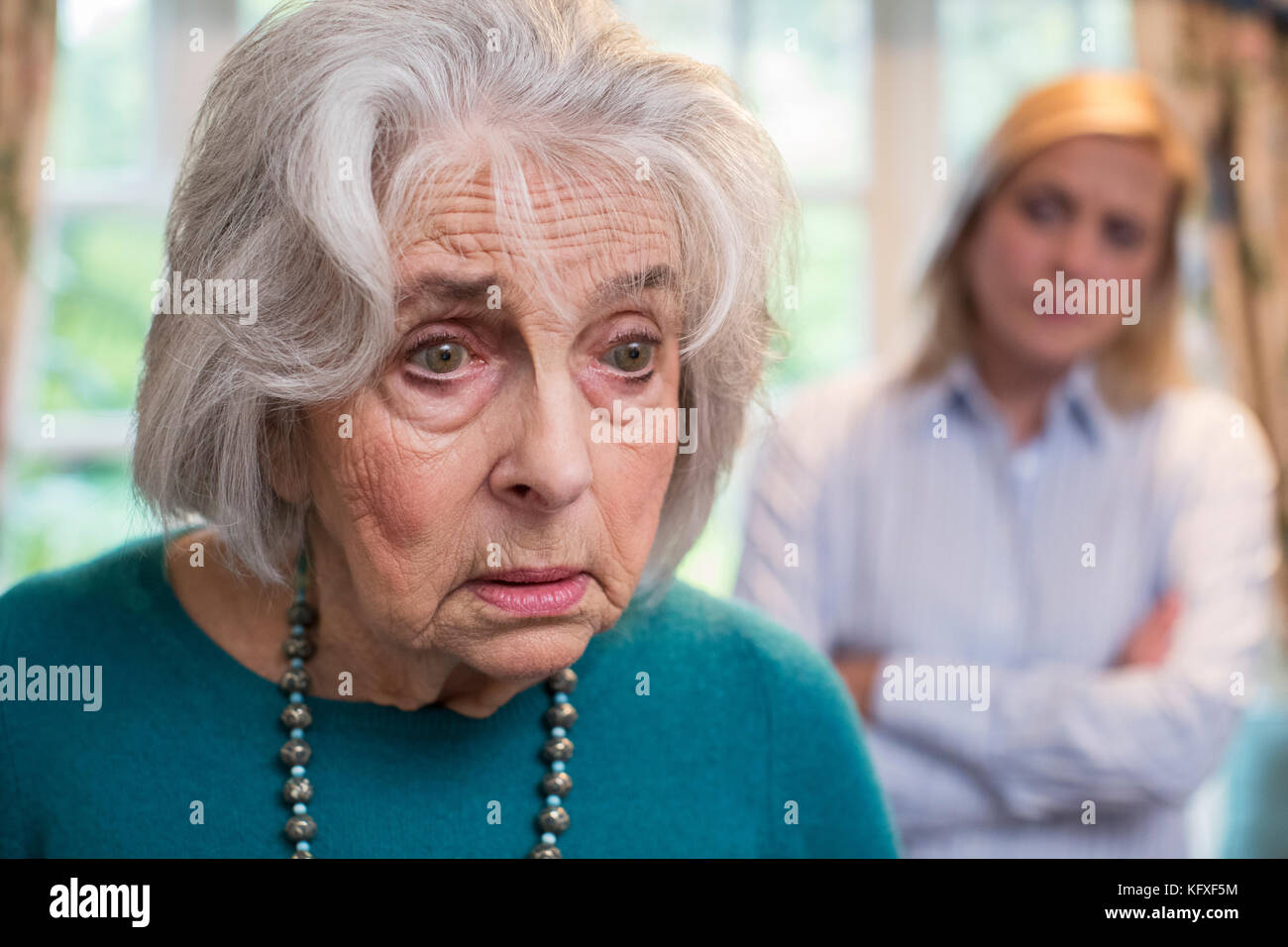Confused Senior Woman With Adult Daughter At Home Stock Photo