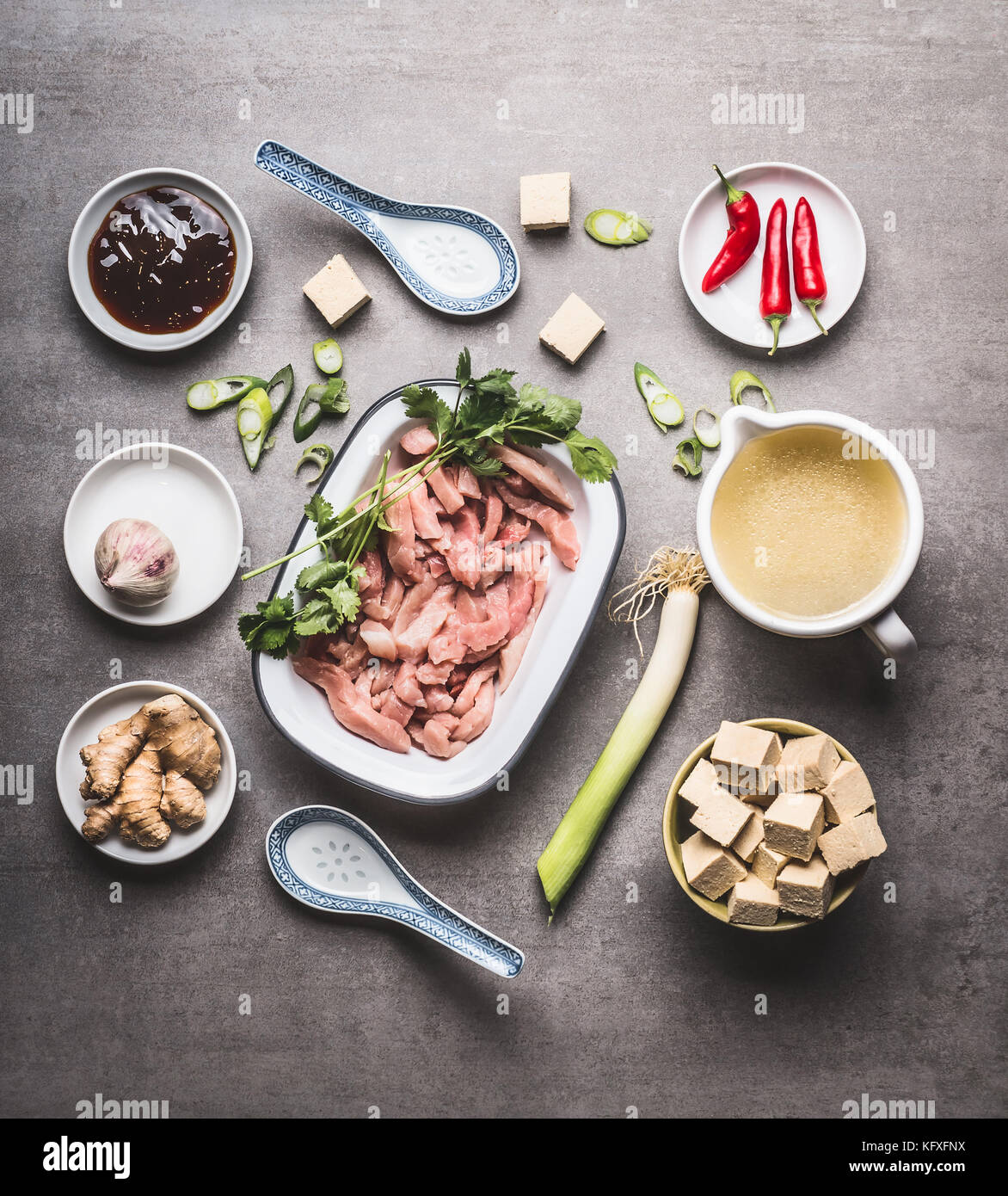 Various asian cooking ingredients in bowls for spicy asian soup with tofu and meat :  sliced meat, ginger, chili, diced tofu ,Oyster sauce, garlic Stock Photo