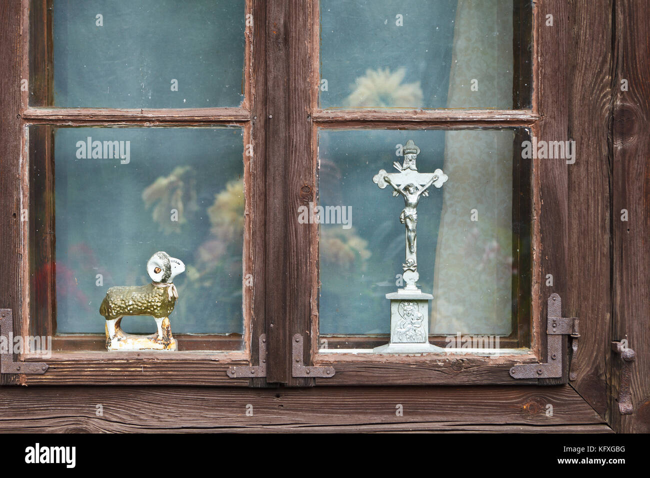 Jesus Christ on cross and lamb figurine in old wooden window Stock Photo