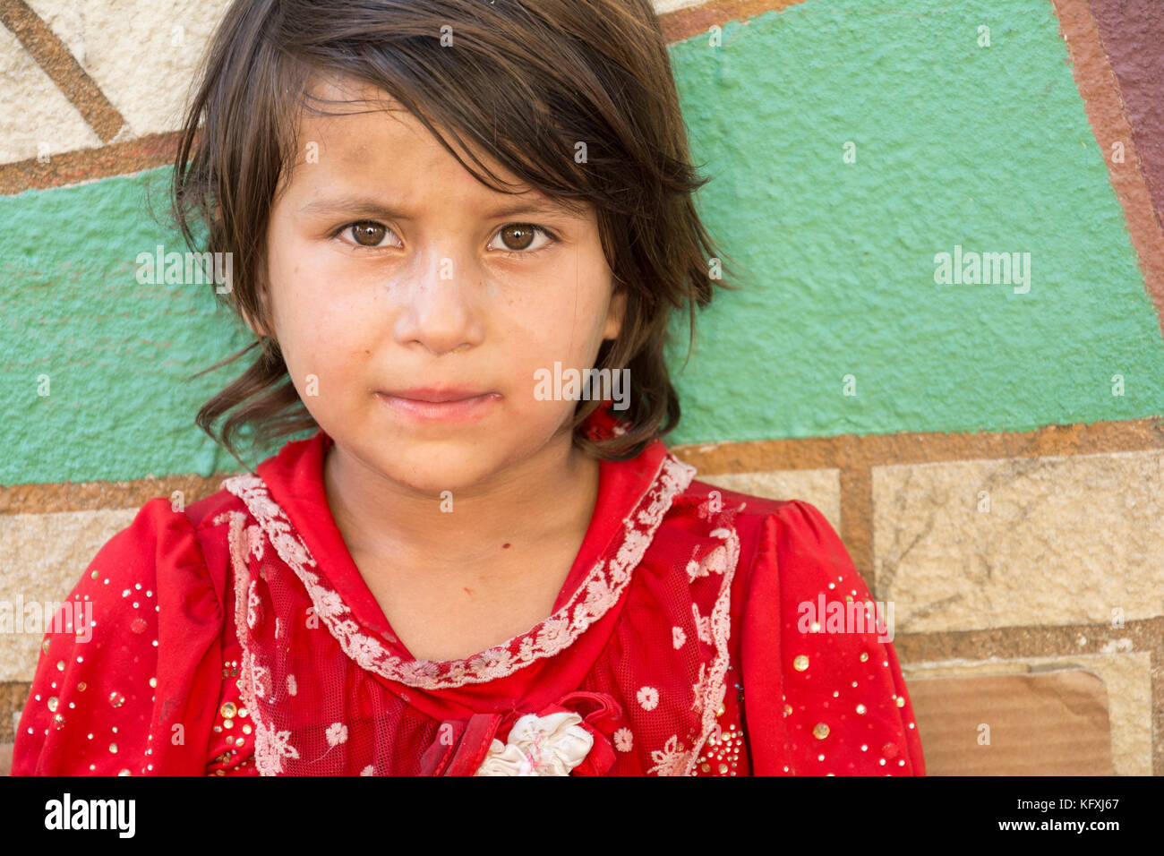 Tehran, IRAN - August 16, 2017 Portrait of a little girl selling small tissue packages at street pavement Stock Photo