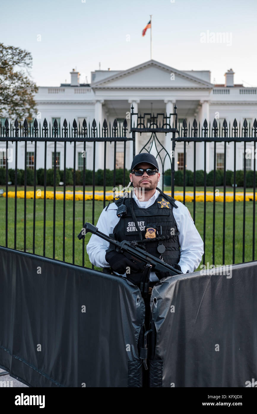 American Secret Service agent armed with a Heckler & Koch MP5 submachine gun standing behind a barricade in front of the White House in Washington, DC Stock Photo