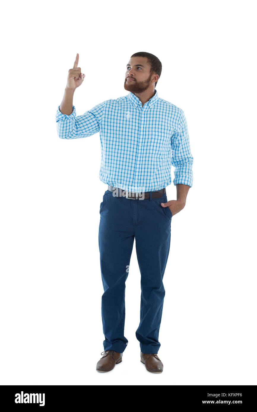 Young male executive pointing upward against white background Stock Photo