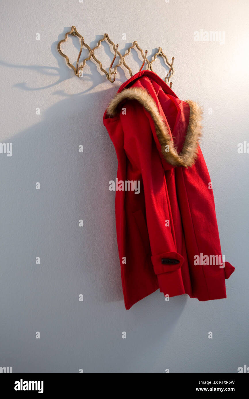 Red hoodie hanging on hook against white background Stock Photo Alamy