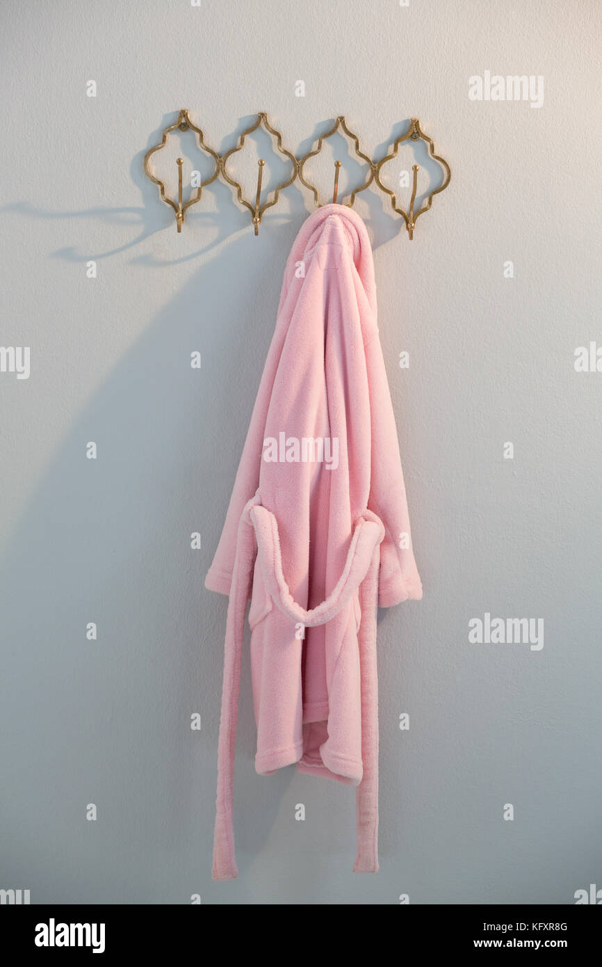 Bathrobe hanging on hook against white wall Stock Photo Alamy