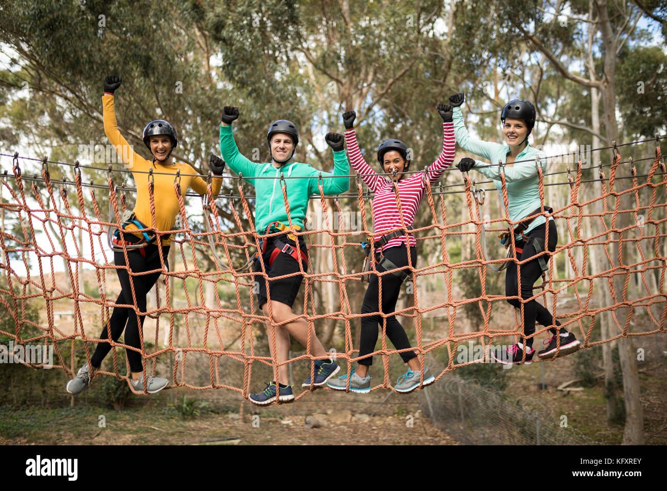 Portrait of happy friends having fun while walking on rope bridge Stock ...