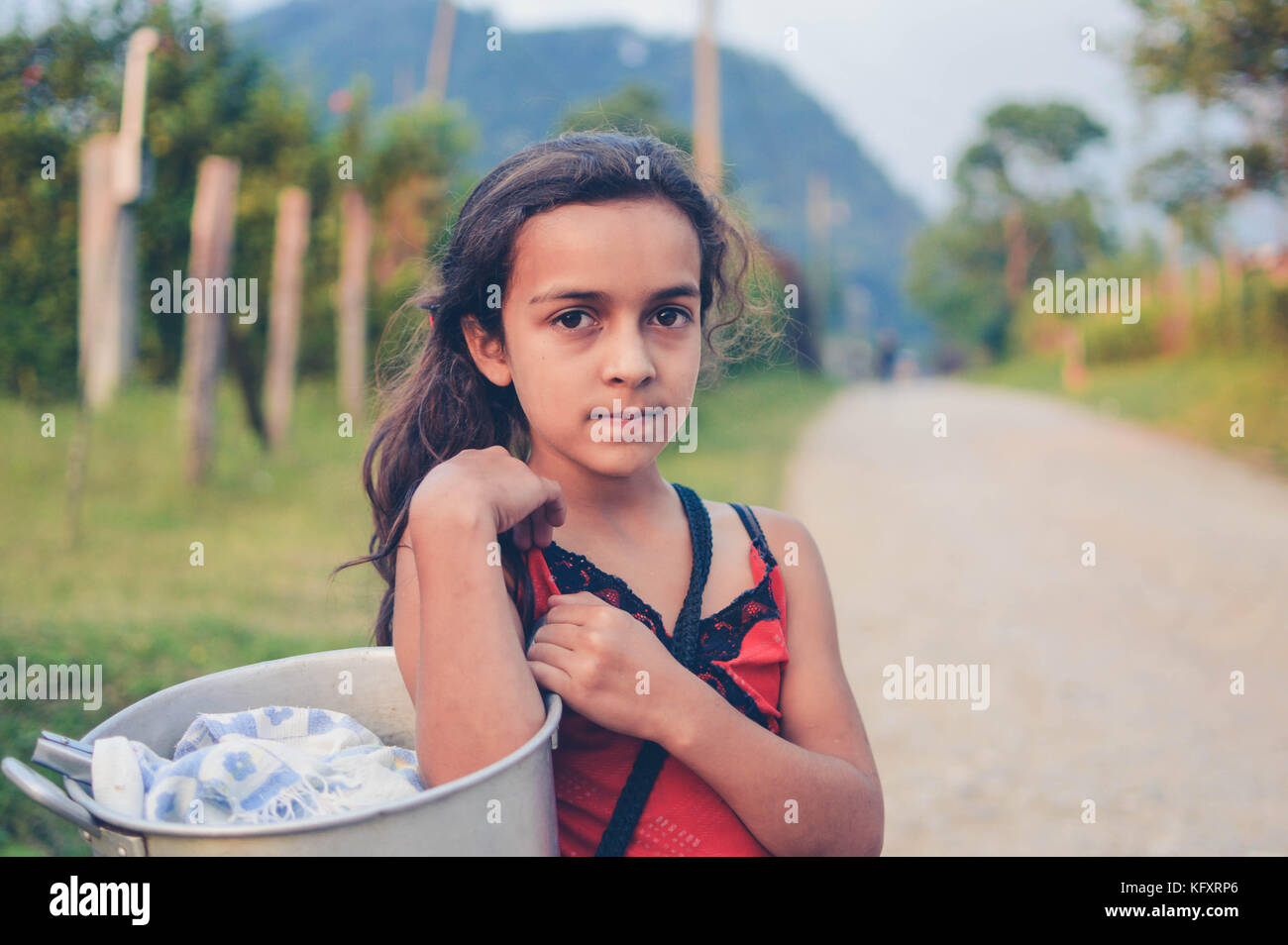 Pena Blanca, Honduras - May 6, 2015: Local girl carries with a pot of tortillas  in a small village of coffee growers in Western Honduras Stock Photo