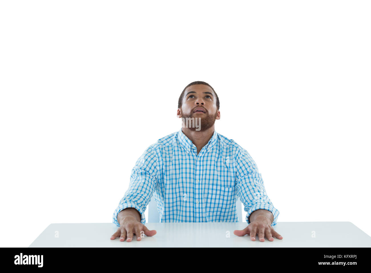 Male executive sitting at desk against white background Stock Photo