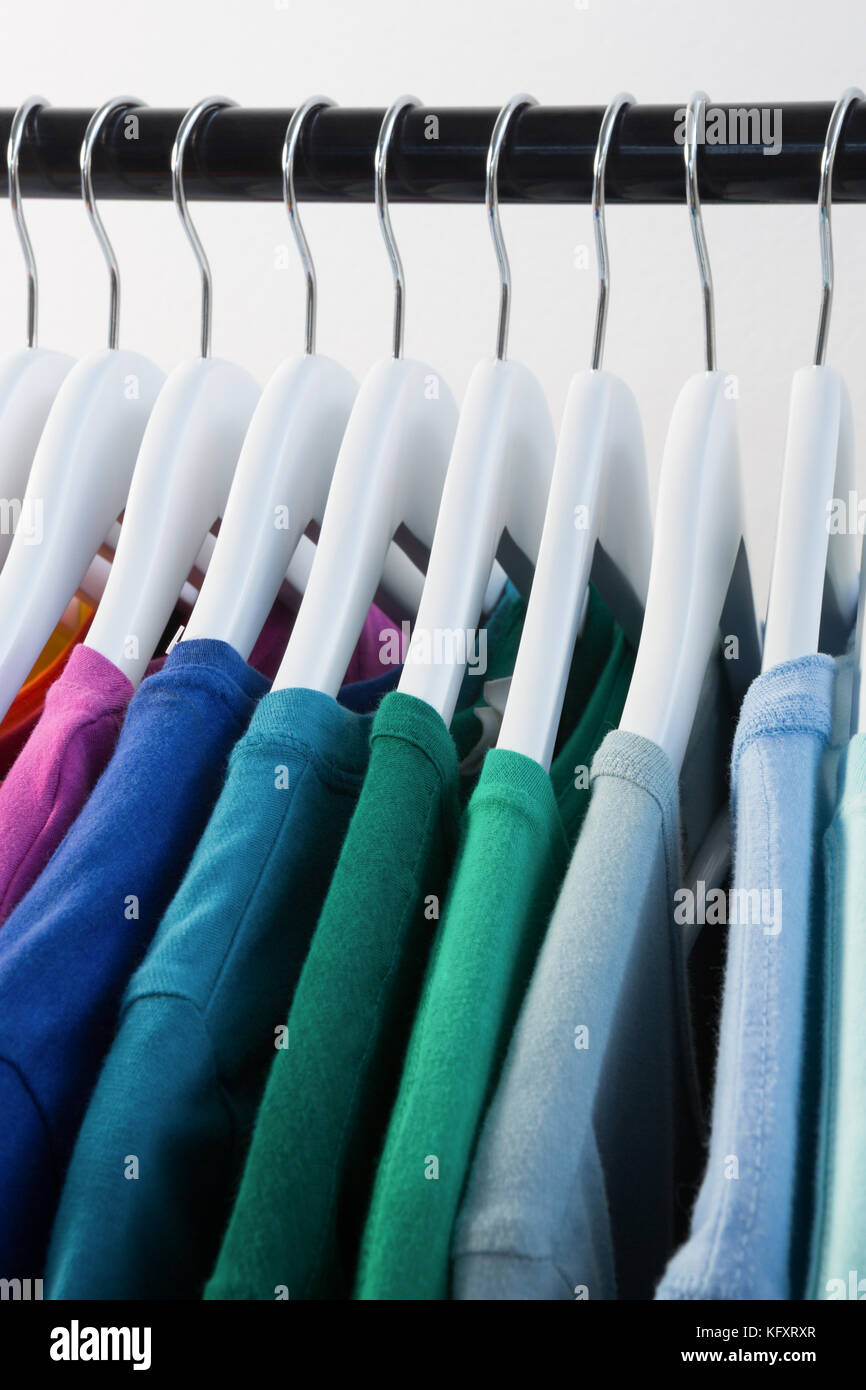 Close-up of colorful t-shirts arranged in a row on cloth rack Stock Photo