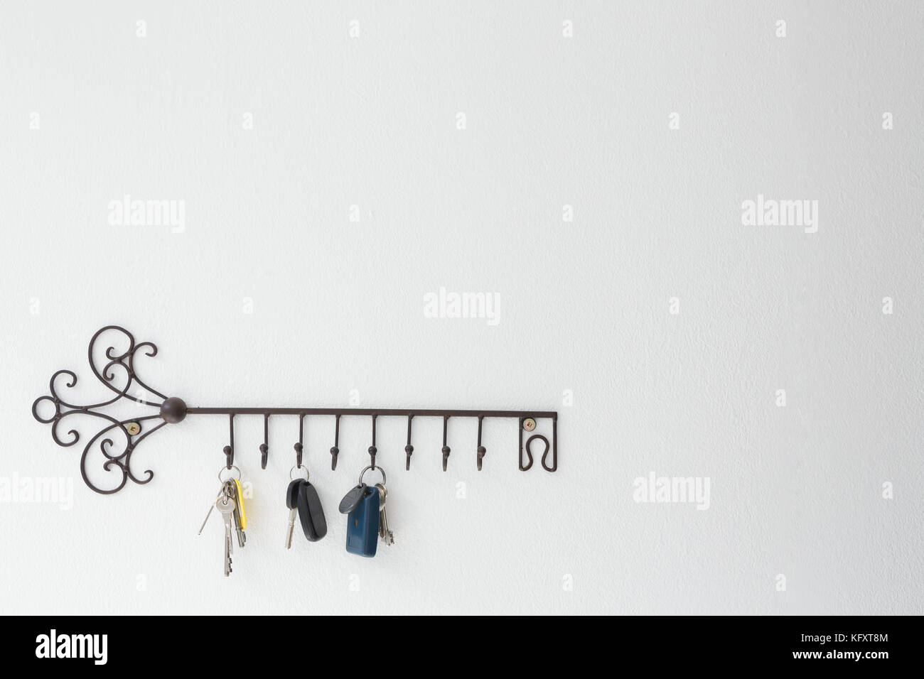 Various keys hanging on hook against white wall Stock Photo Alamy