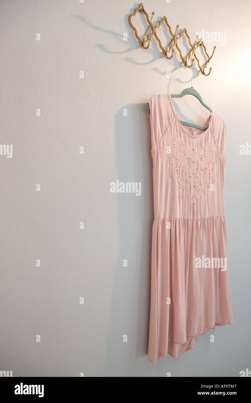 Dress hanging on hook against white wall Stock Photo Alamy