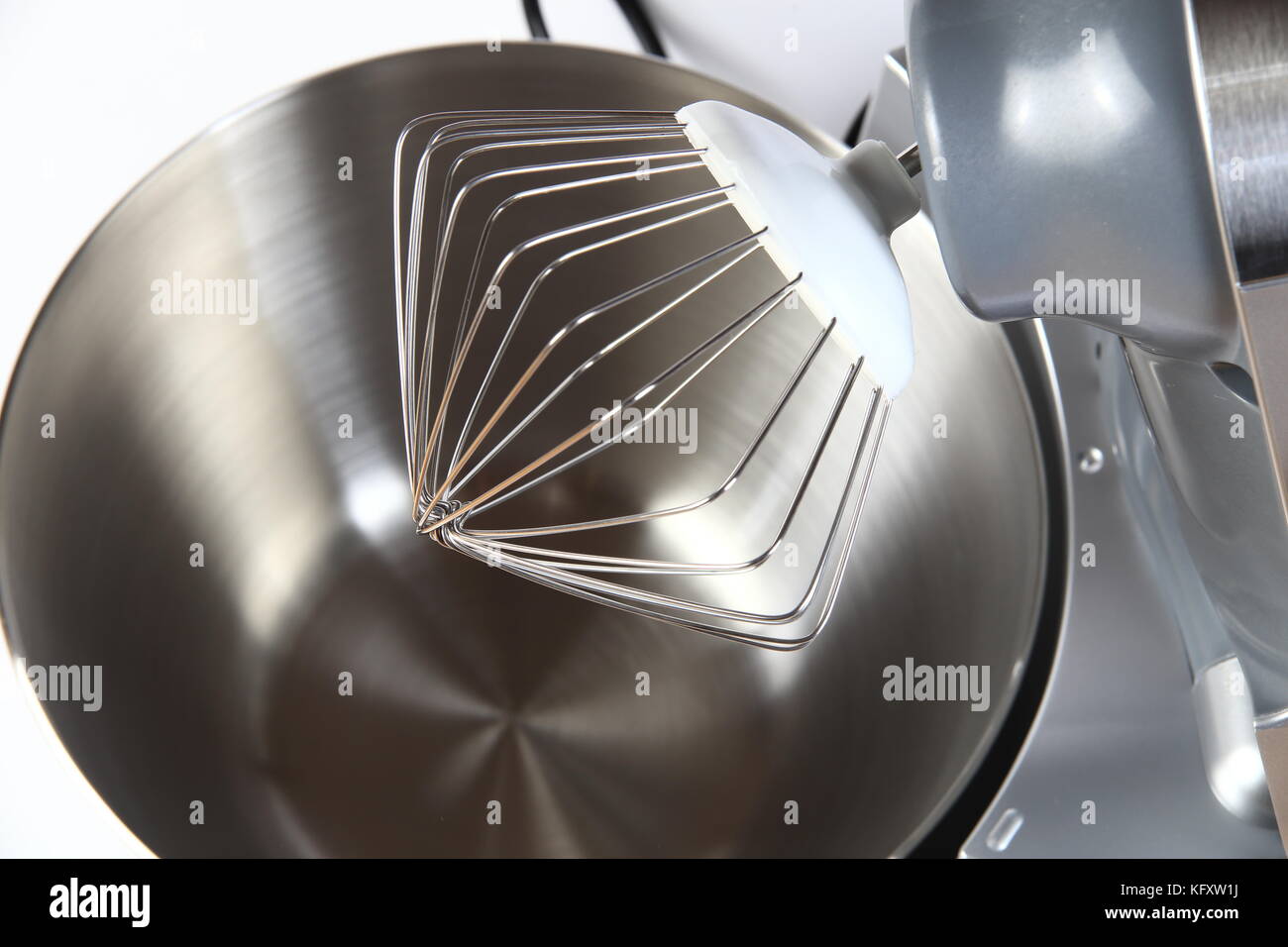 Steel whisk of new food processor close-up. Whisk on steel bowl background. Stock Photo
