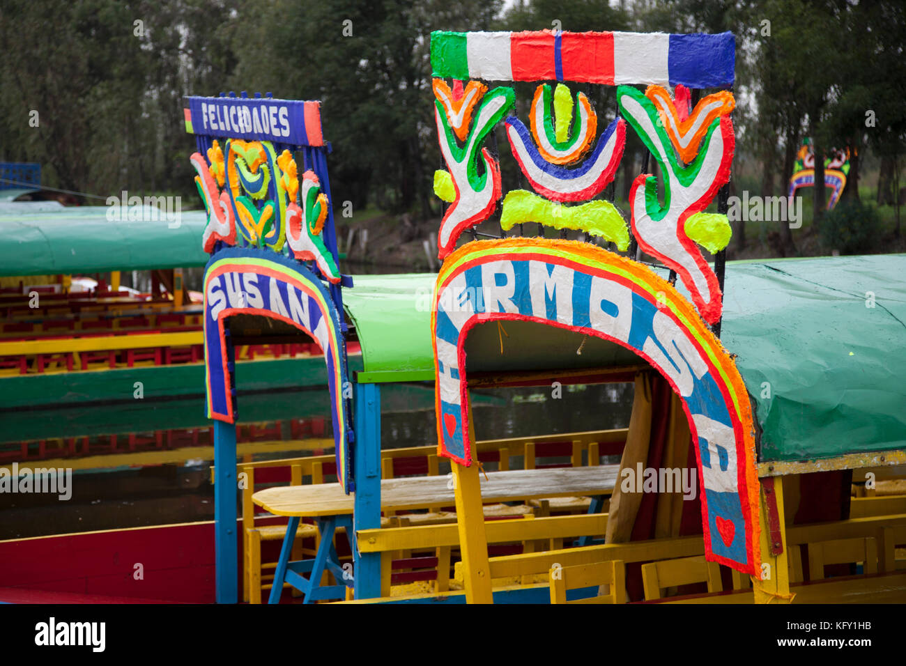 Colorful boats waiting to take visitors on a tour of the chinampas, or floating gardens, of Xochimilco in Mexico City. Stock Photo