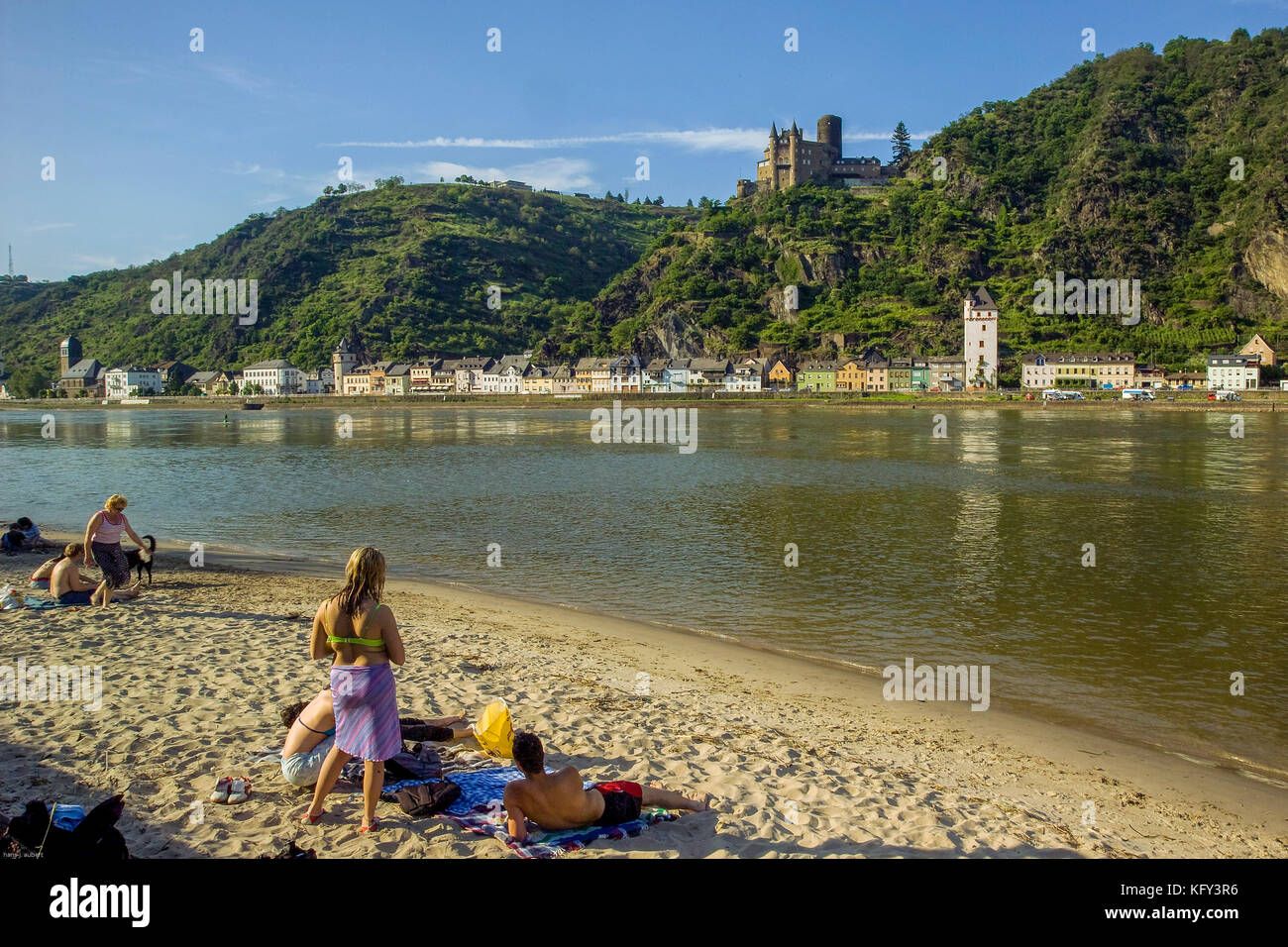 GERMANY. Bathers enjoying a sunny summerday at the bank of the Rhine River opposite Sankt Goarshausen and castle Katz Stock Photo