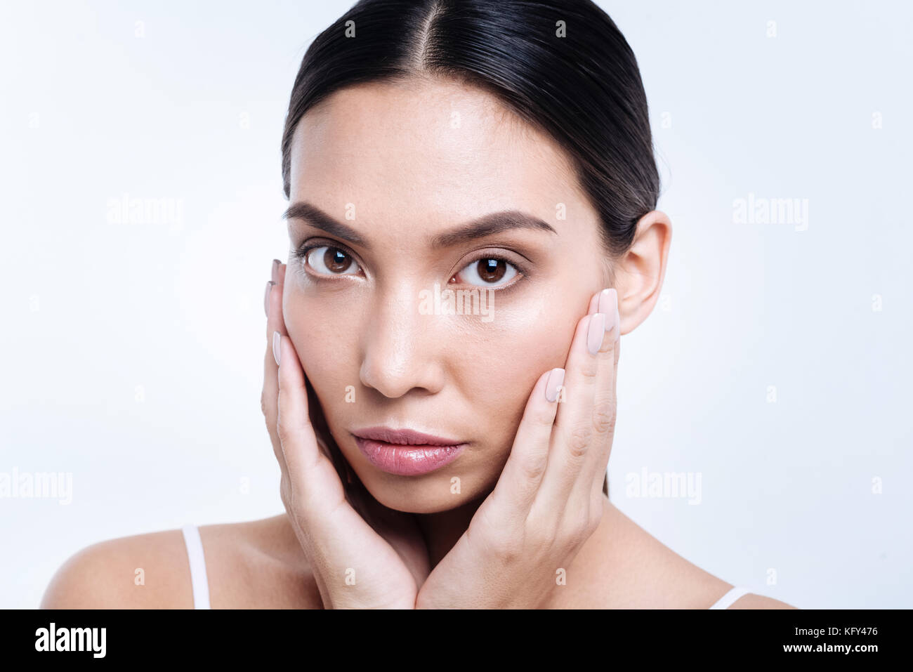 Beautiful darkhaired woman cupping her face with hands Stock Photo Alamy