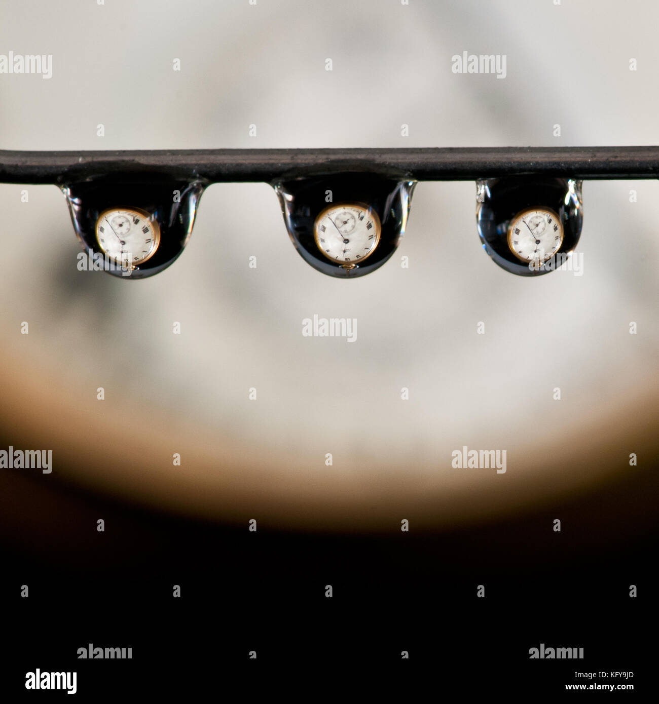 Three water droplets displaying an old pocket watch within each droplet! Stock Photo
